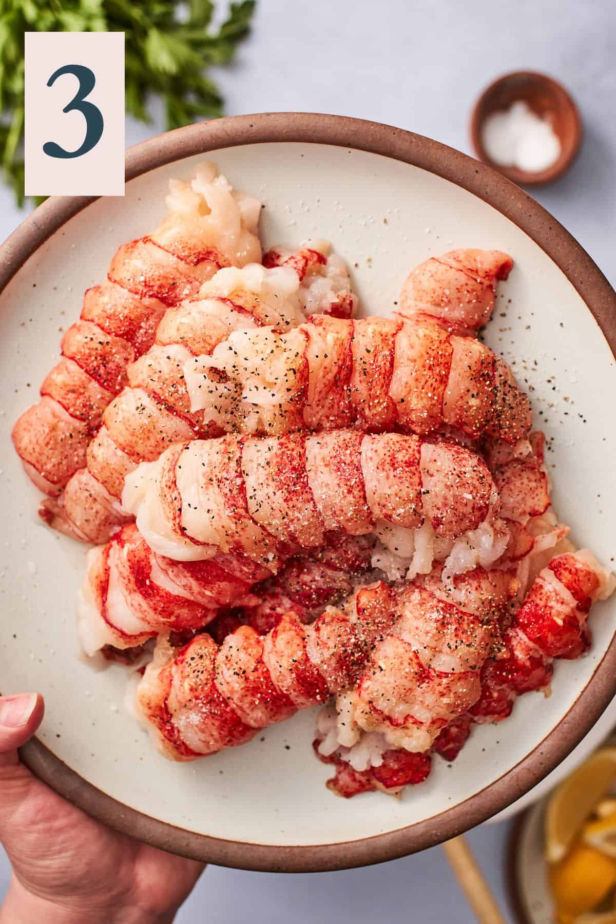 lobster tail meat on a plate sprinkled with salt and pepper.
