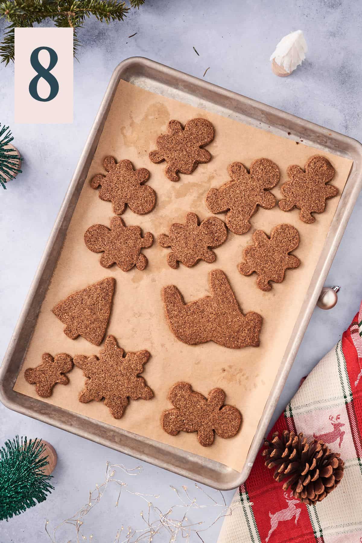 baked gingerbread cookies on a parchment lined baking sheet.