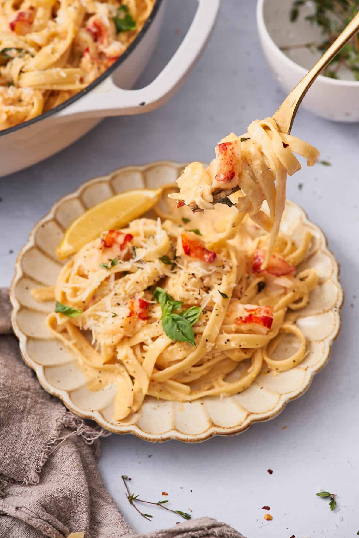 lobster pasta with noodles on a plate, and a fork full of noodles. 