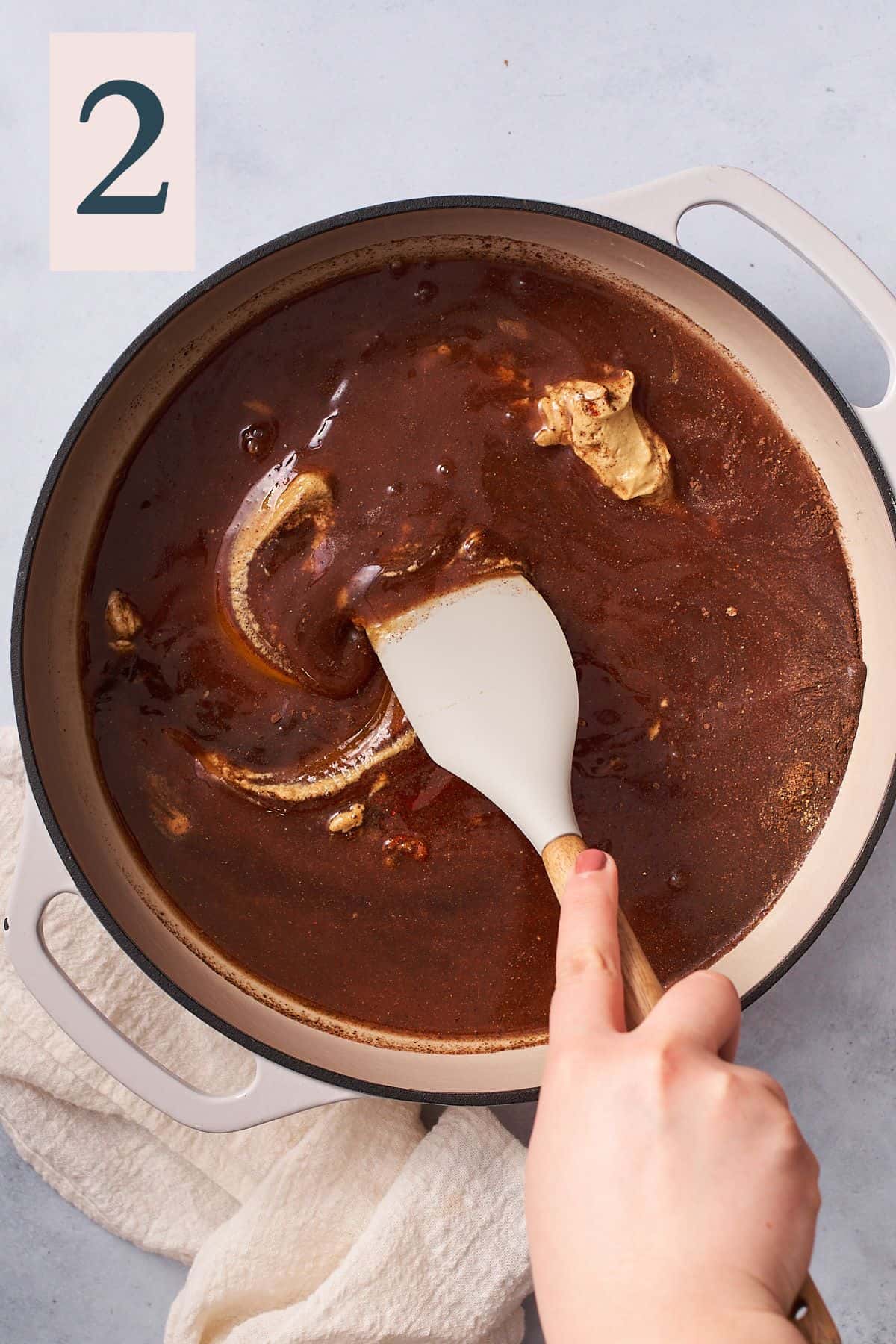 hand mixing sauce ingredients in an enameled cast iron with dijon. 