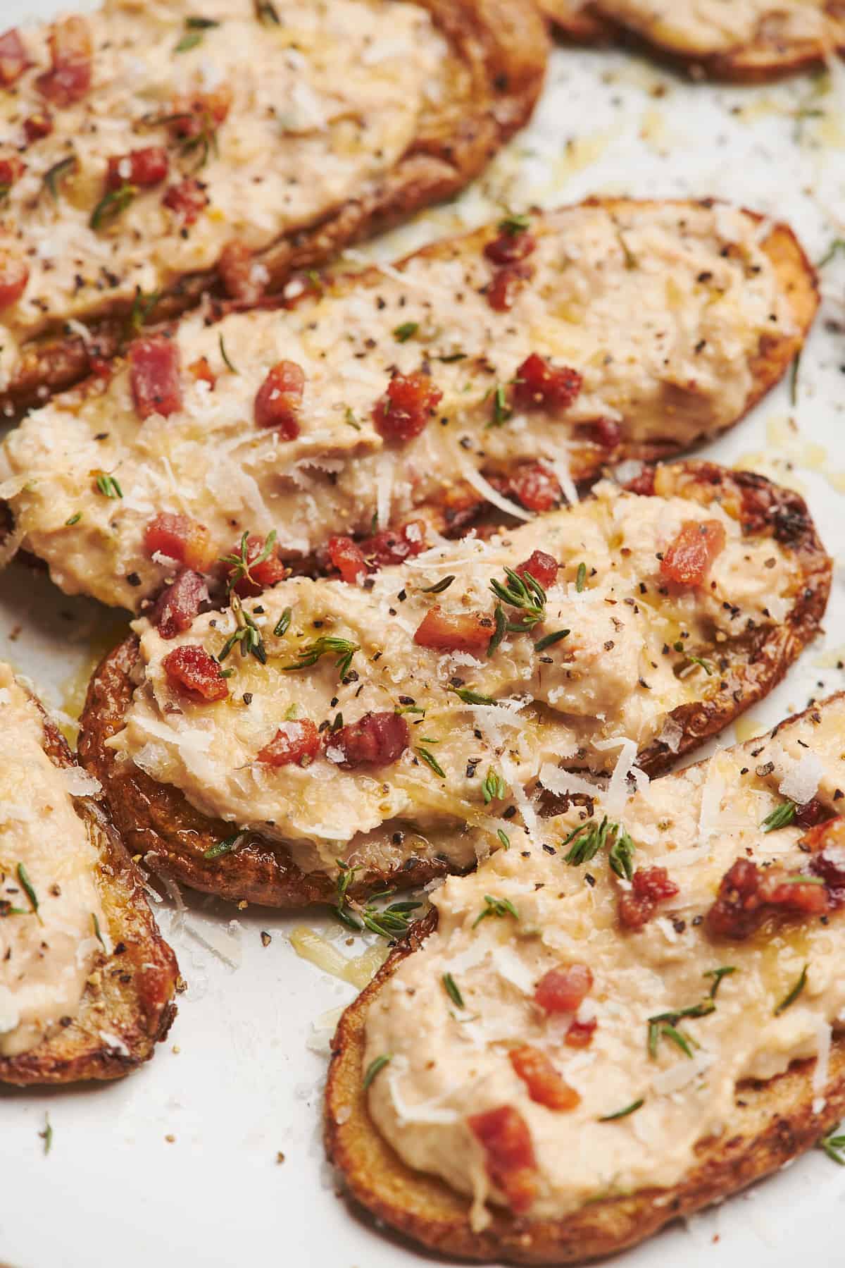 tuna appetizer spread on a thin potato wedge, topped with parmesan cheese, crispy pancetta, and fresh thyme. 