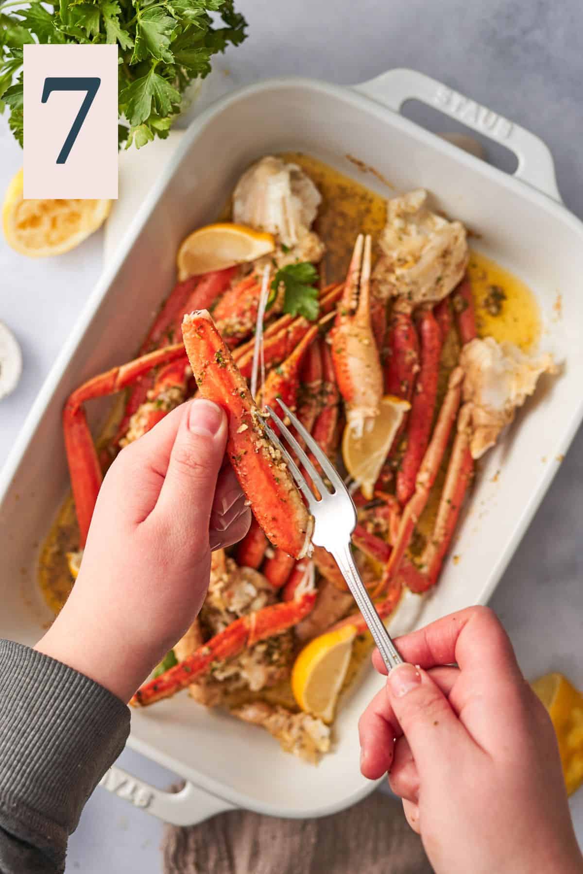 Inserting a fork inside a crab leg to remove the meat.