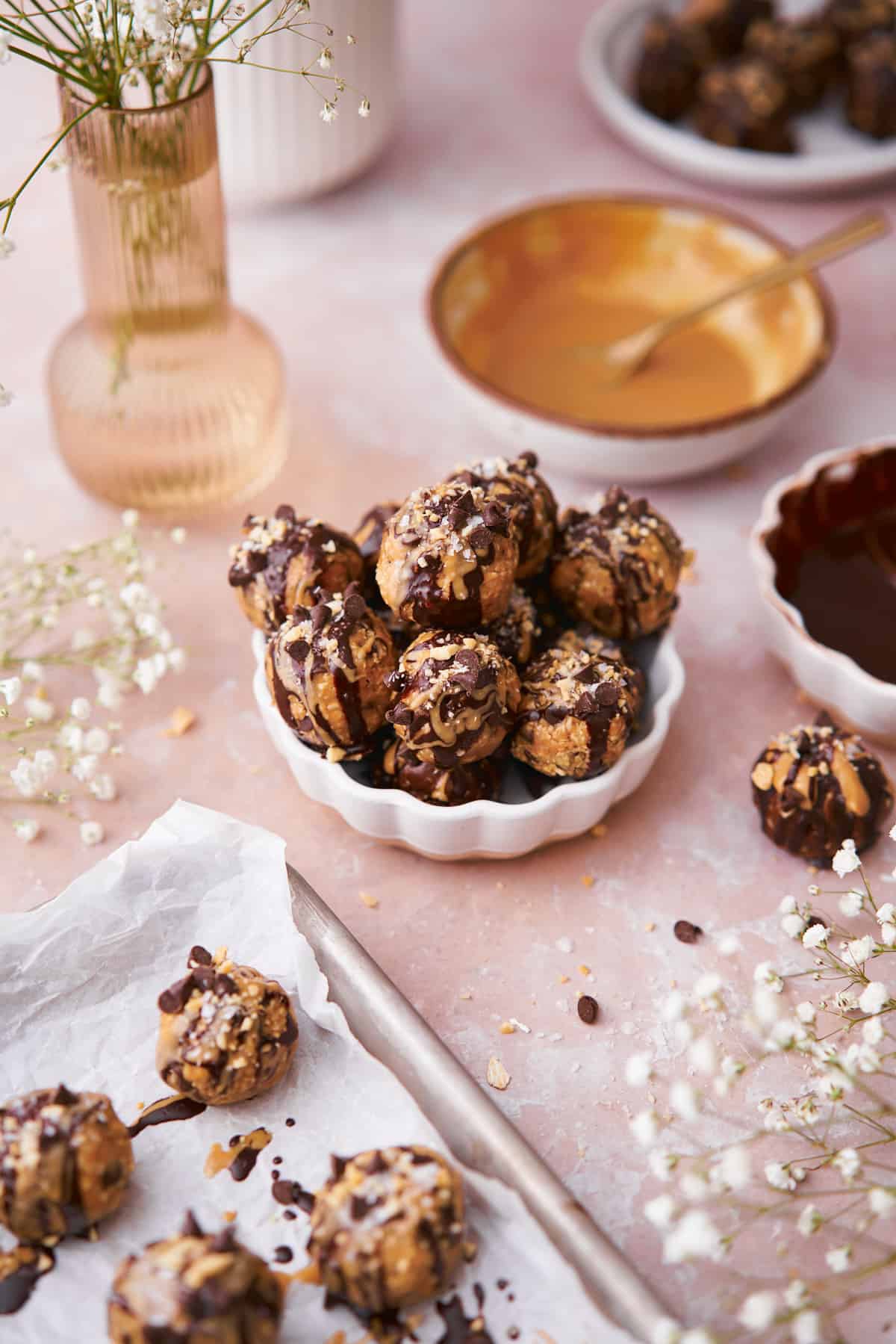 bliss balls topped with melted chocolate, peanut butter, chocolate chips, peanuts, and flaky salt. 