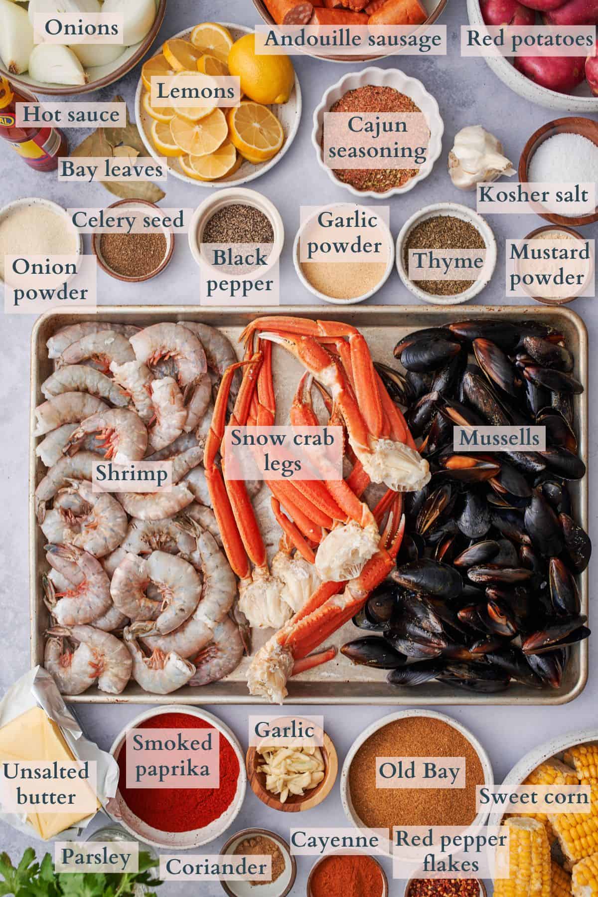 ingredients to make a cajun seafood boil laid out in small bowls with text overlaying to denote each ingredient. 