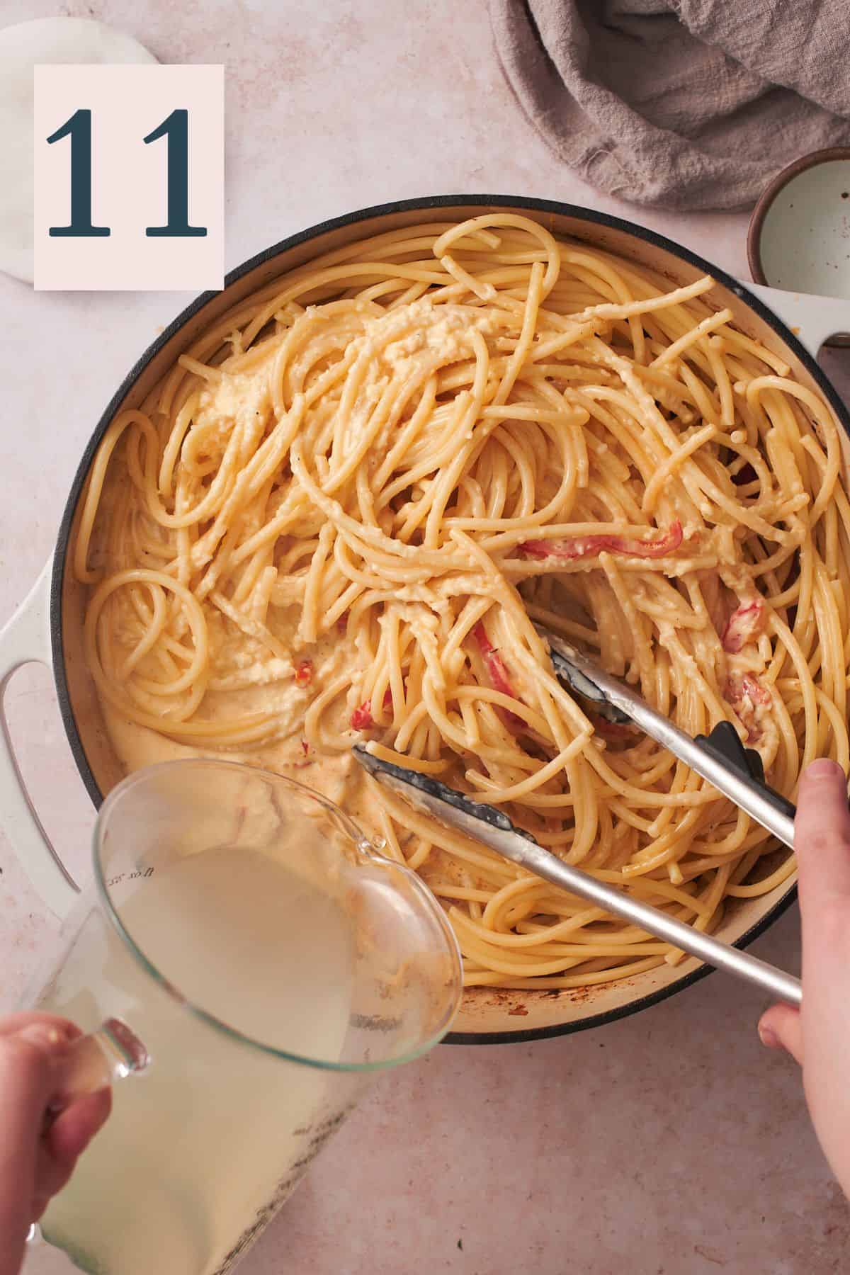 hand tossing pasta with tongs and pouring in pasta water to form a sauce.