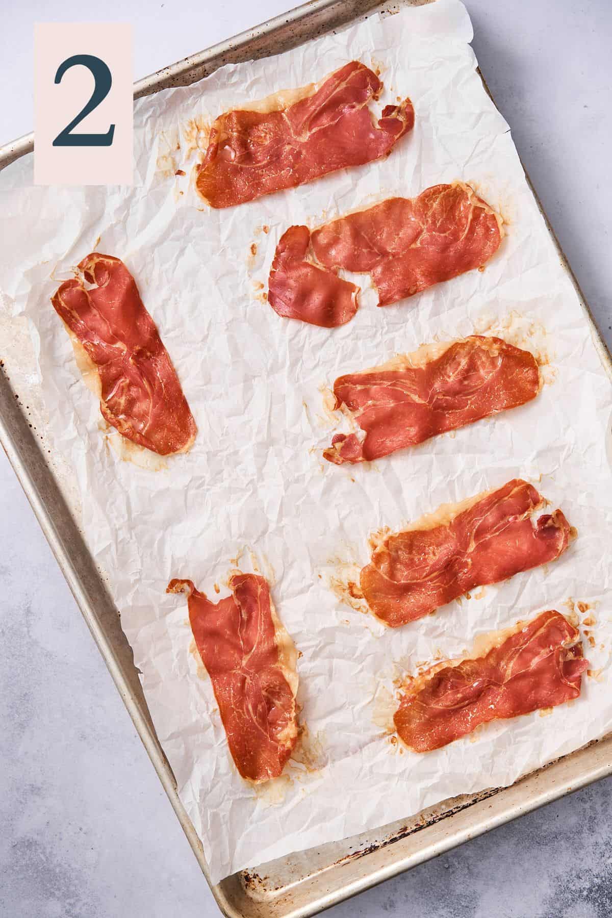 cooked and crispy prosciutto on a parchment lined baking sheet.