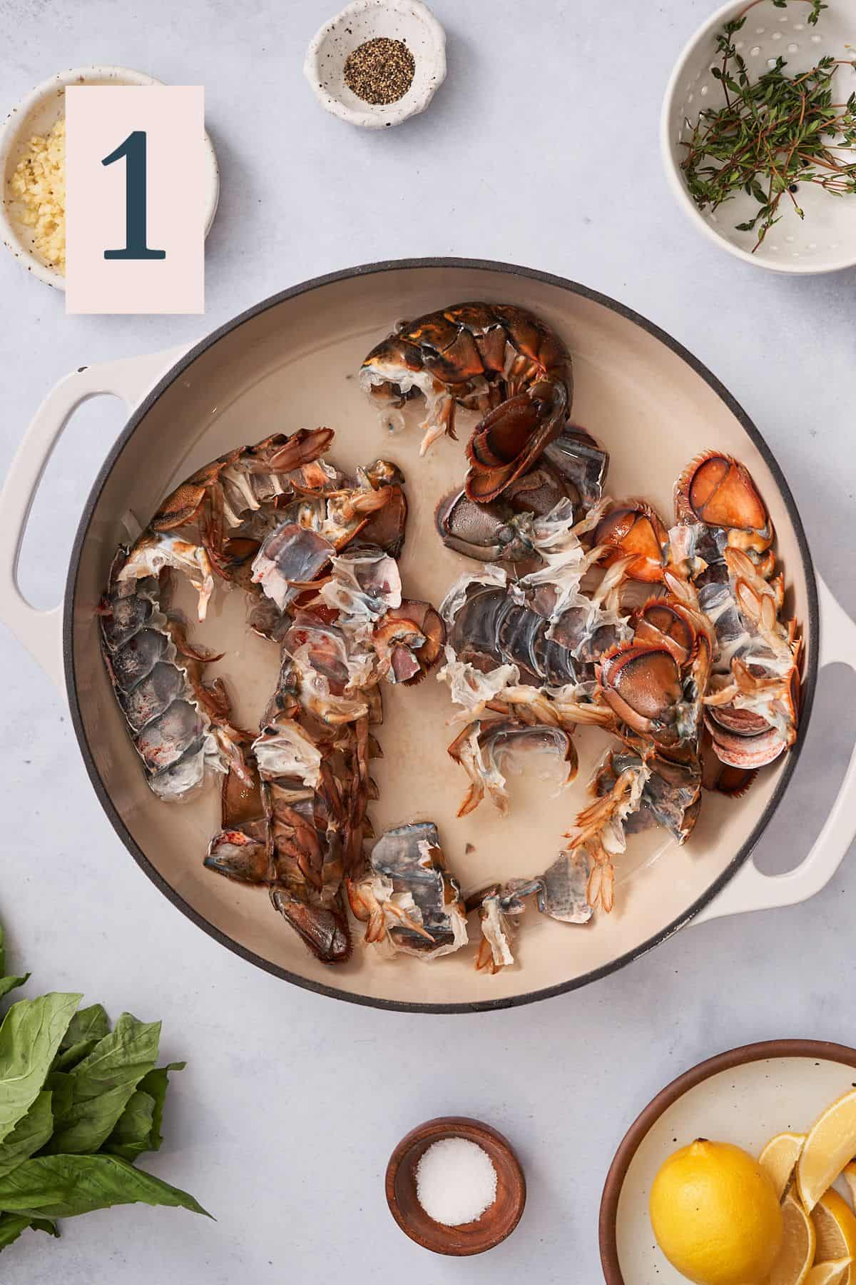 lobster shells in a large enameled skillet with liquid in the skillet. 