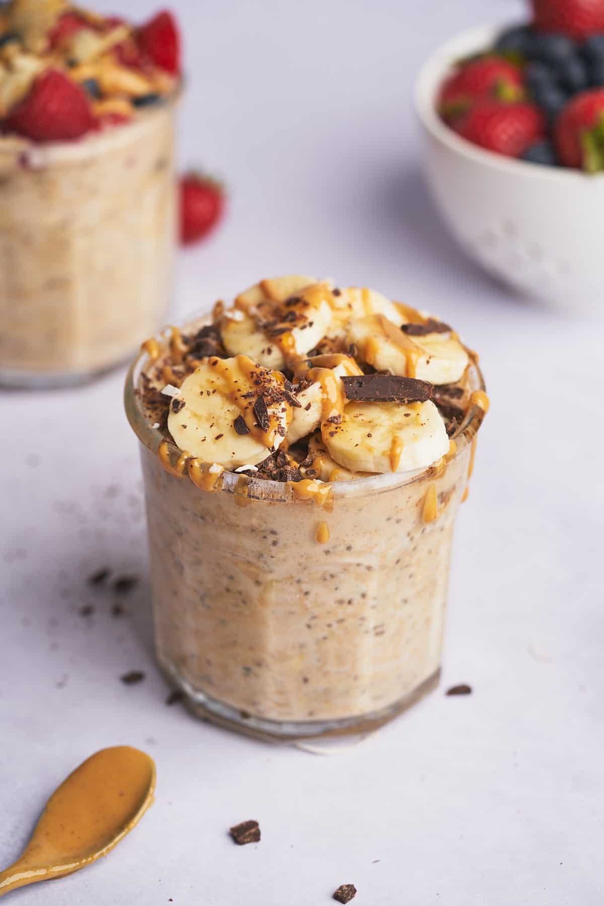 protein overnight oats topped with bananas, peanut butter, and chocolate pieces.