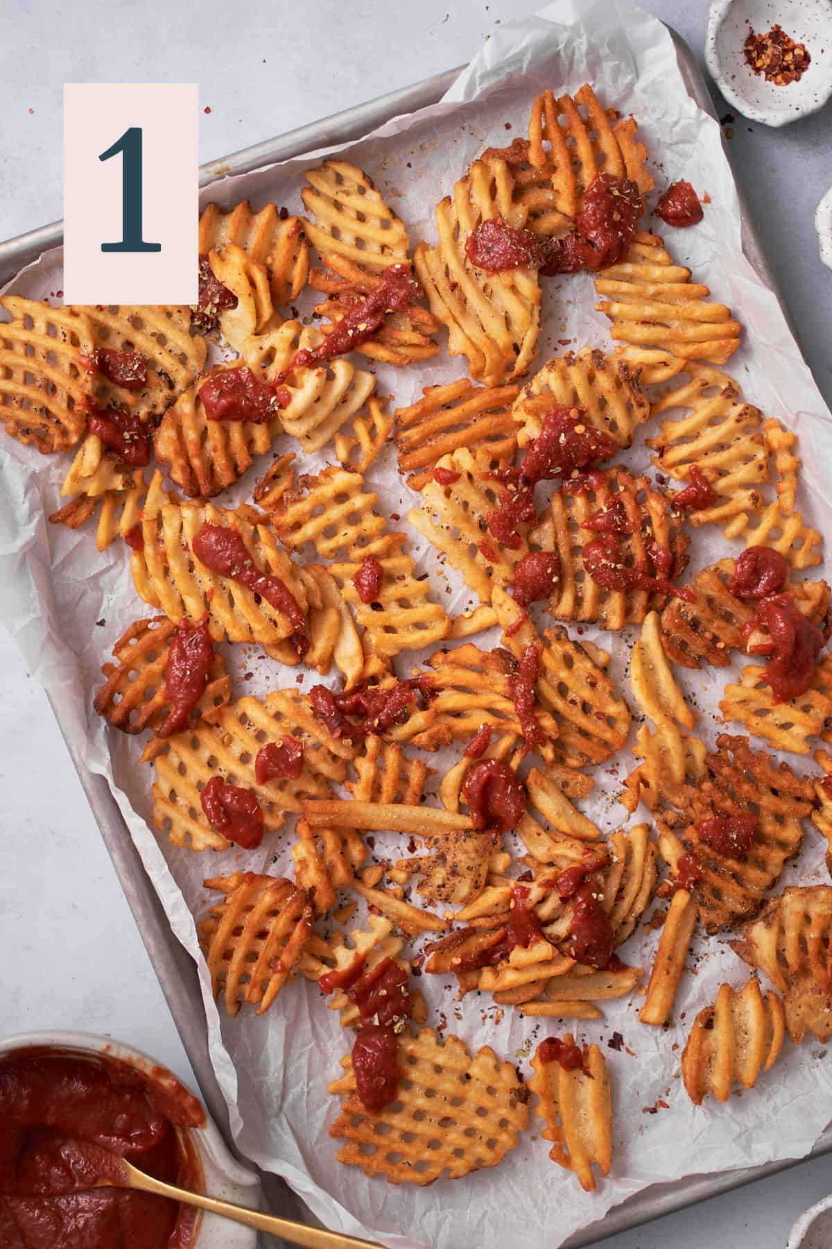 Waffle fries with pizza sauce, oregano, red pepper flakes, and garlic on top.