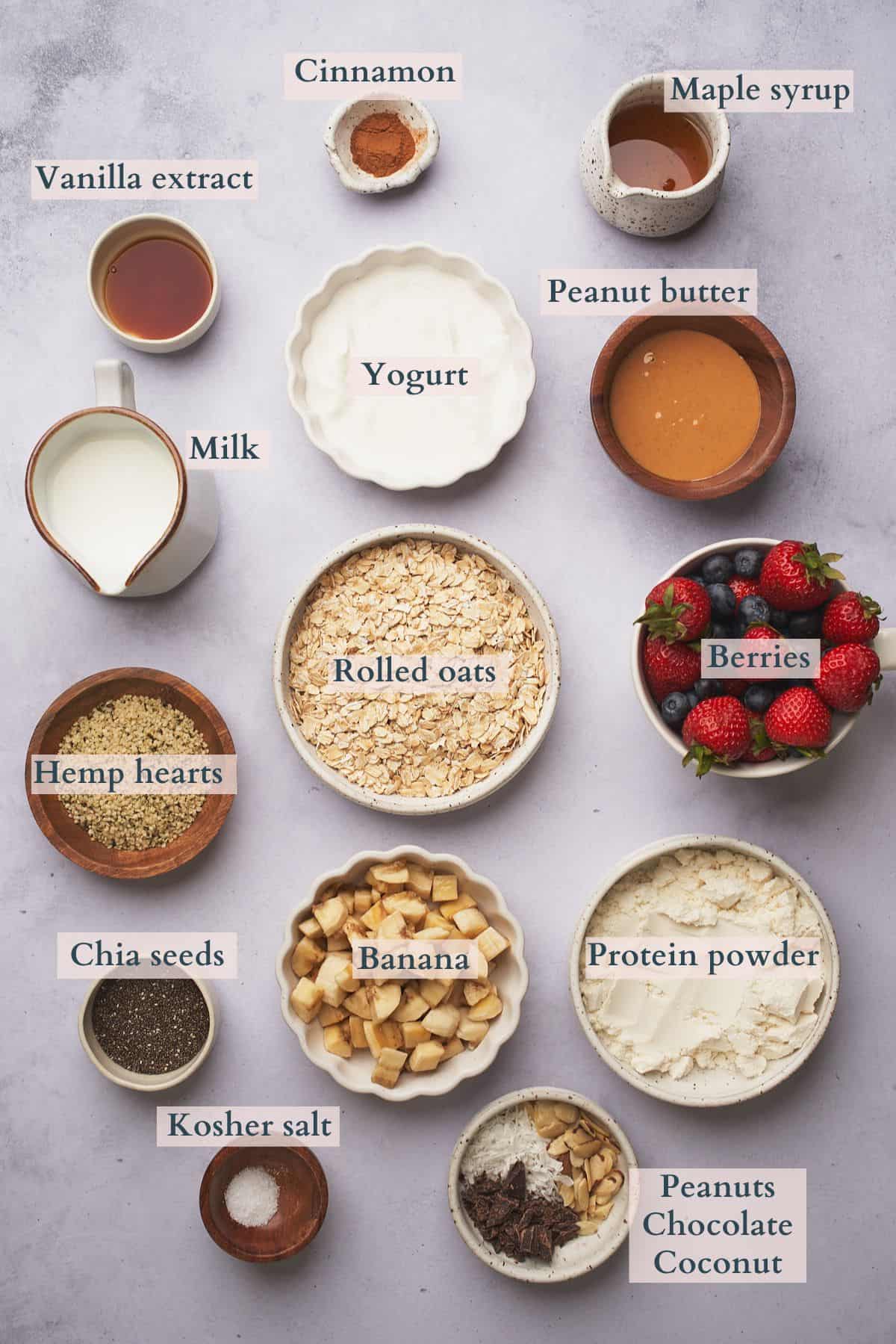 ingredients to make protein overnight oats in ceramic bowls, with text overlaying to denote each ingredient. 