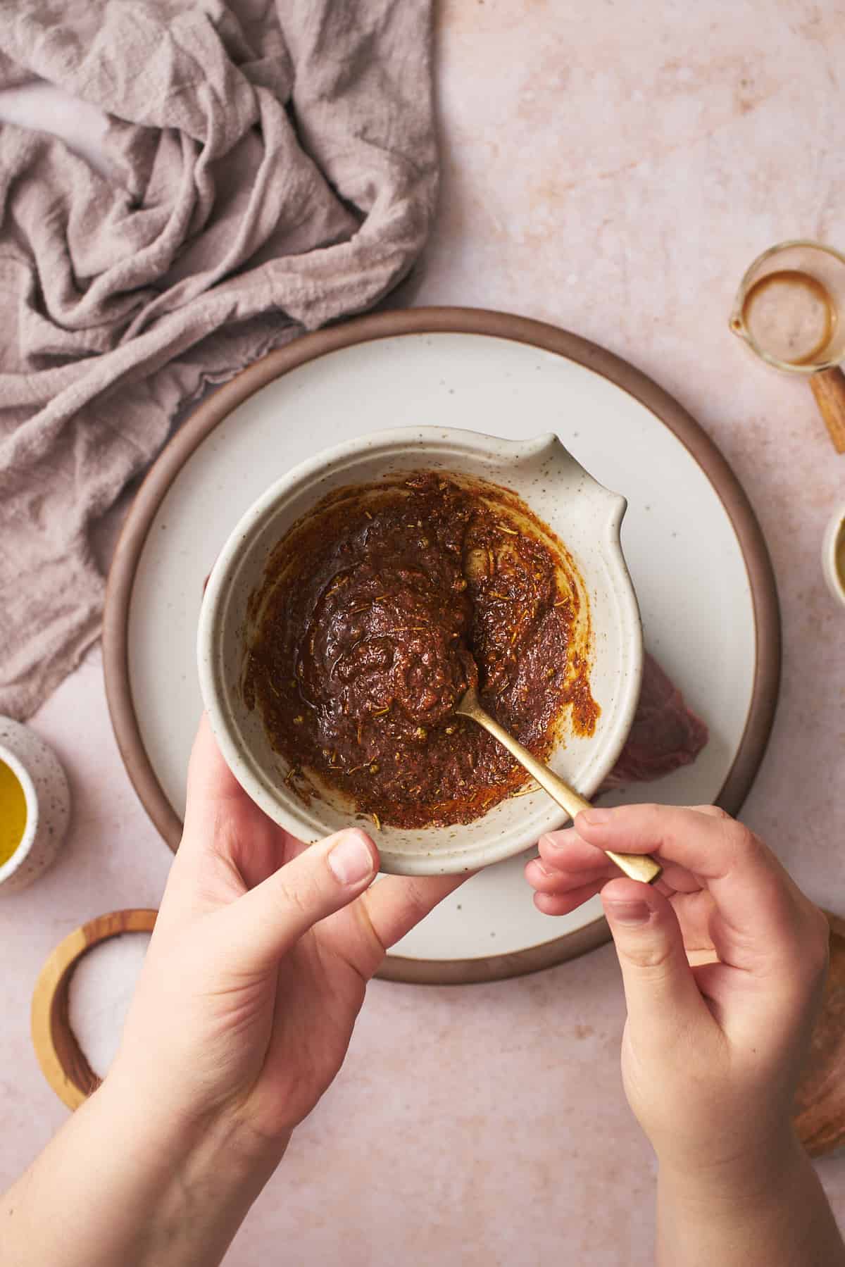 Mixing up seasonings, mustard, and oil in a small bowl to add to a roast.