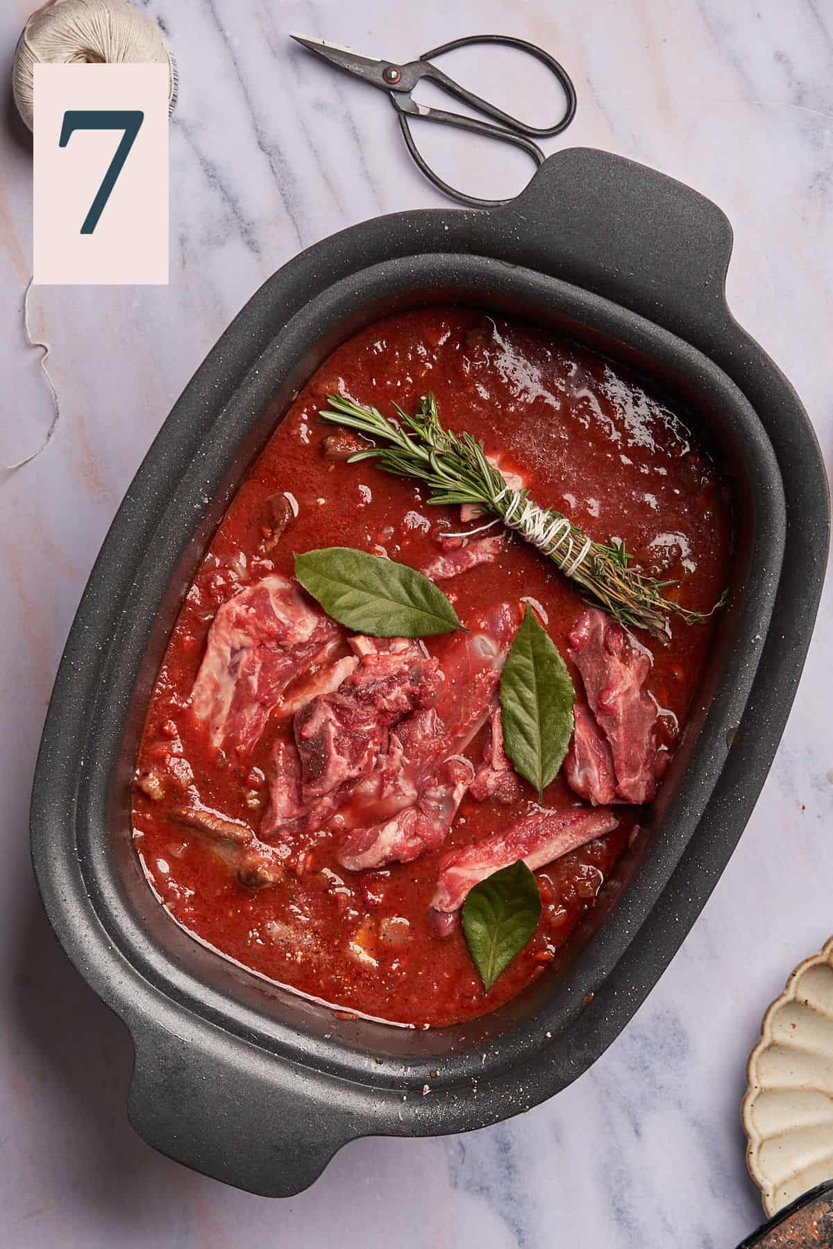 hearty and rich tomato sauce with lamb bones, bay leaves, and fresh herbs in a bundle secured with twine in a slow cooker. 