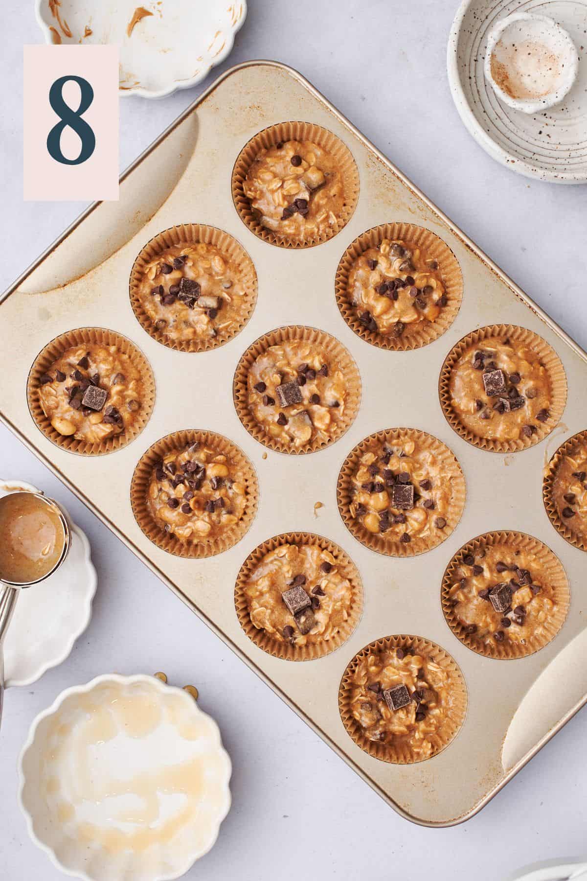 Oatmeal cup mixture transferred to muffin tin inside of muffin liners.