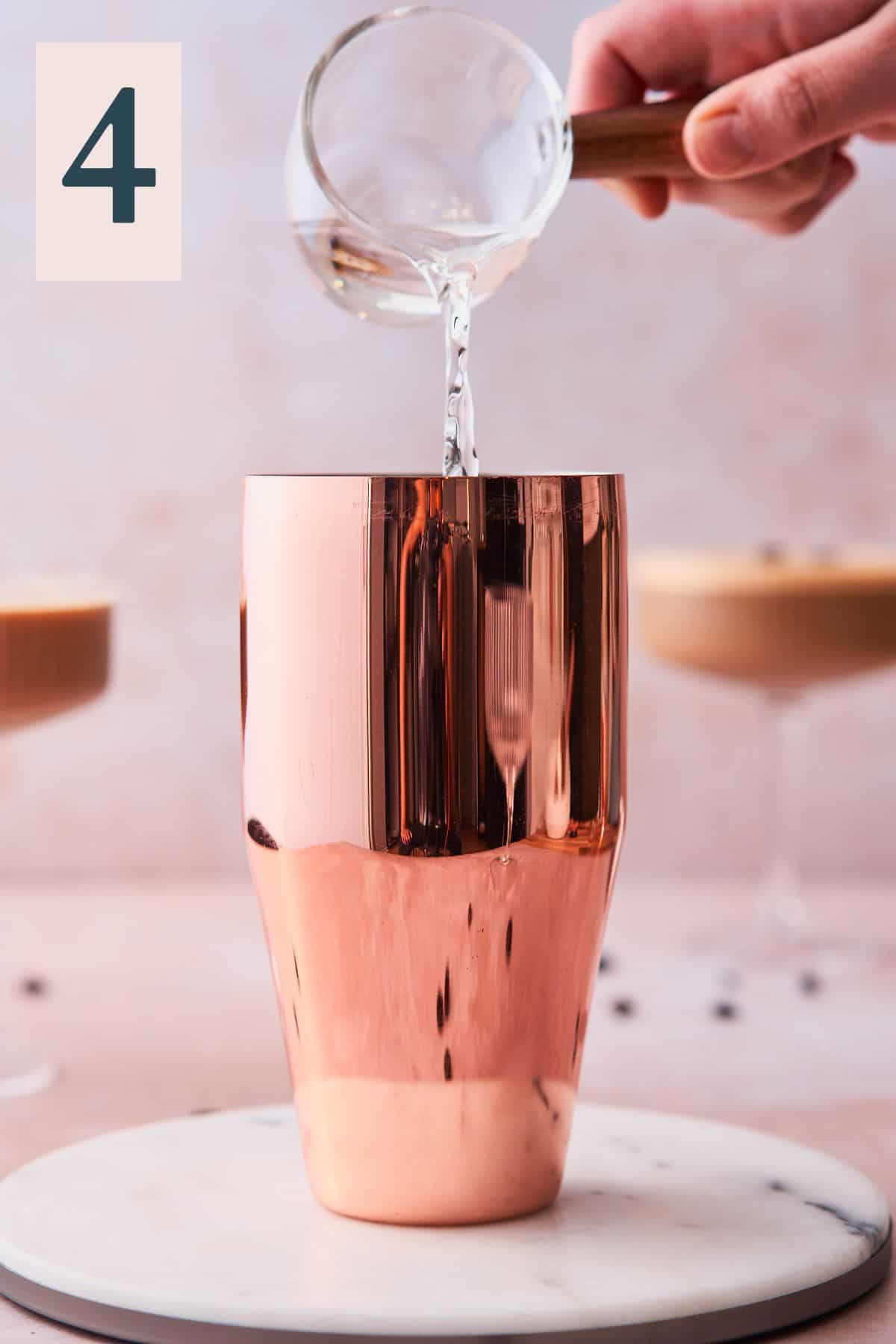 hand pouring vodka into a rose gold cocktail shaker and espresso martinis. 