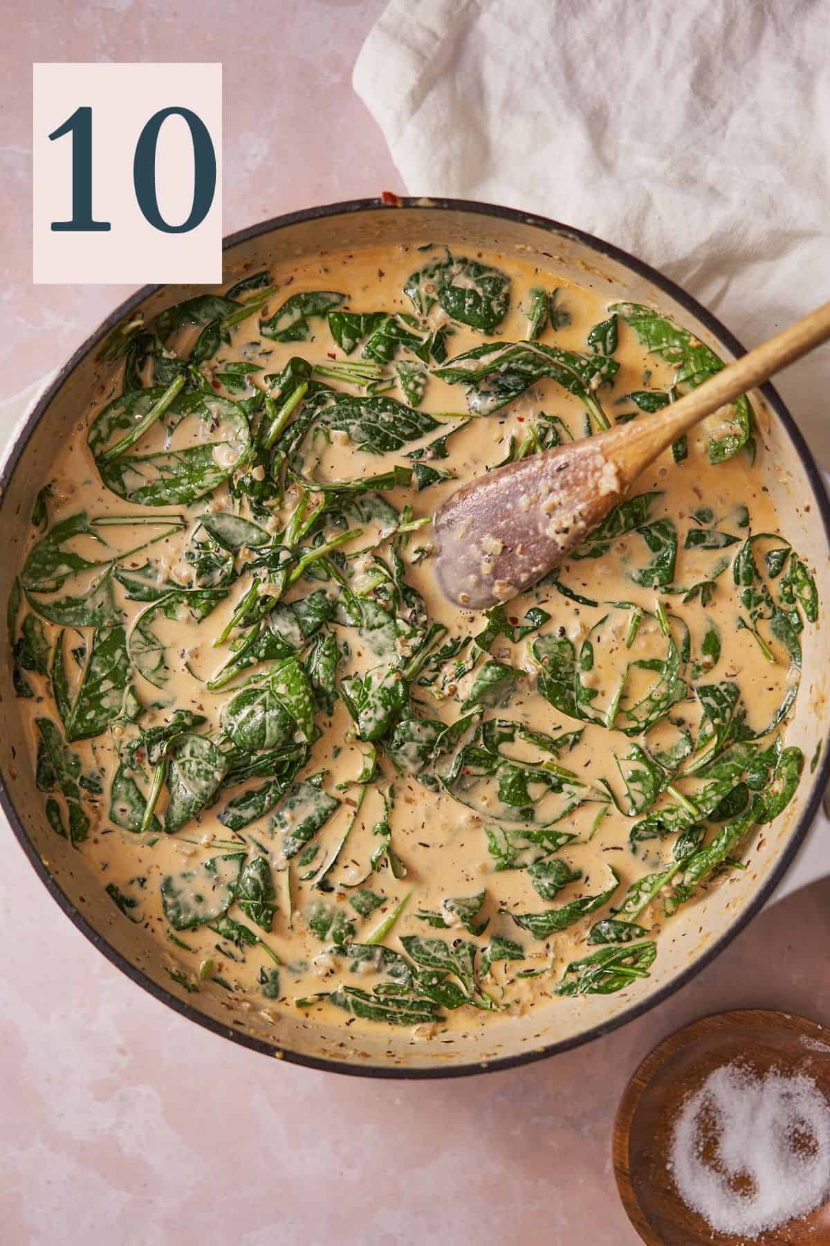 wilted spinach in a cream sauce in a cast iron skillet. 