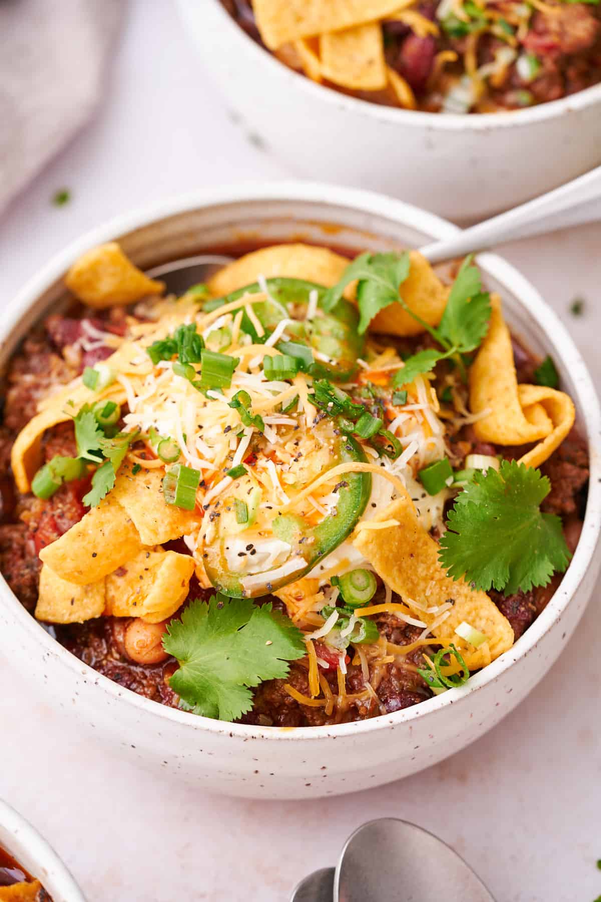 Chili in a bowl with various personalized toppings.