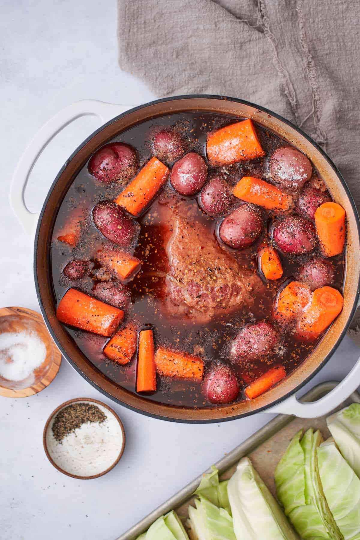 corned beef in a Dutch oven with a flavorful braising liquid, baby potatoes, and carrots, with lots of salt.