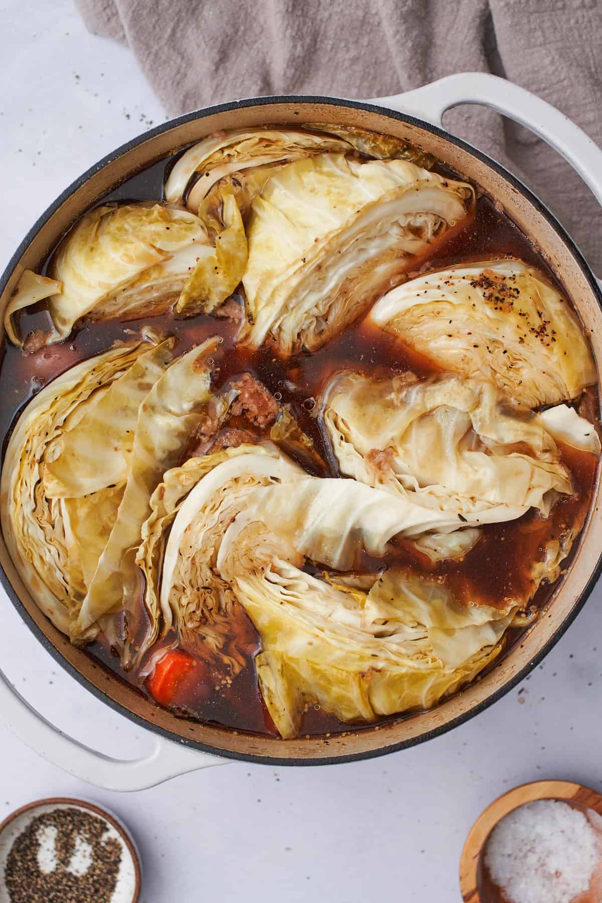 cooked and wilted cabbage in a dutch oven with broth.