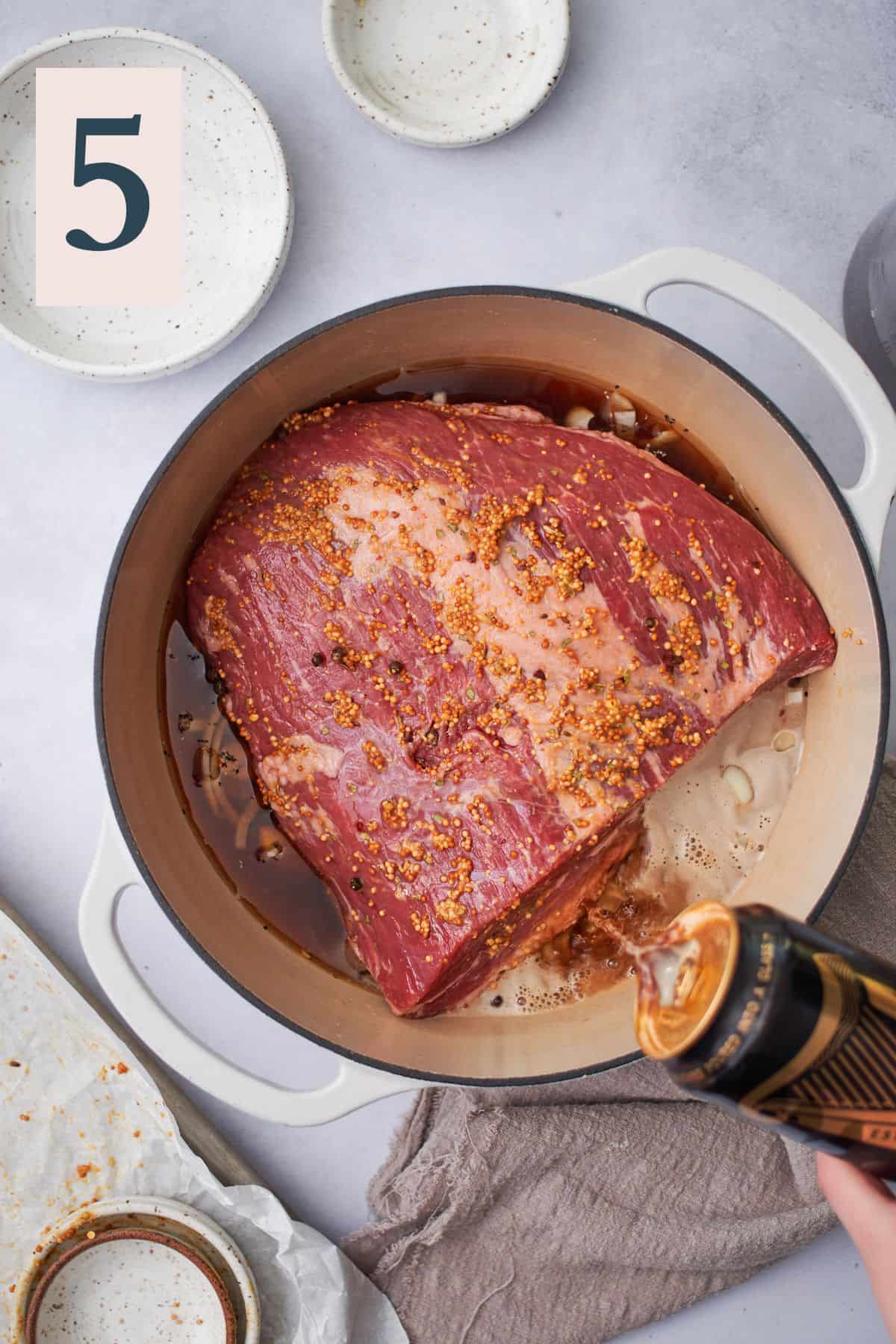 pouring guinness into a dutch oven with corned beef. 