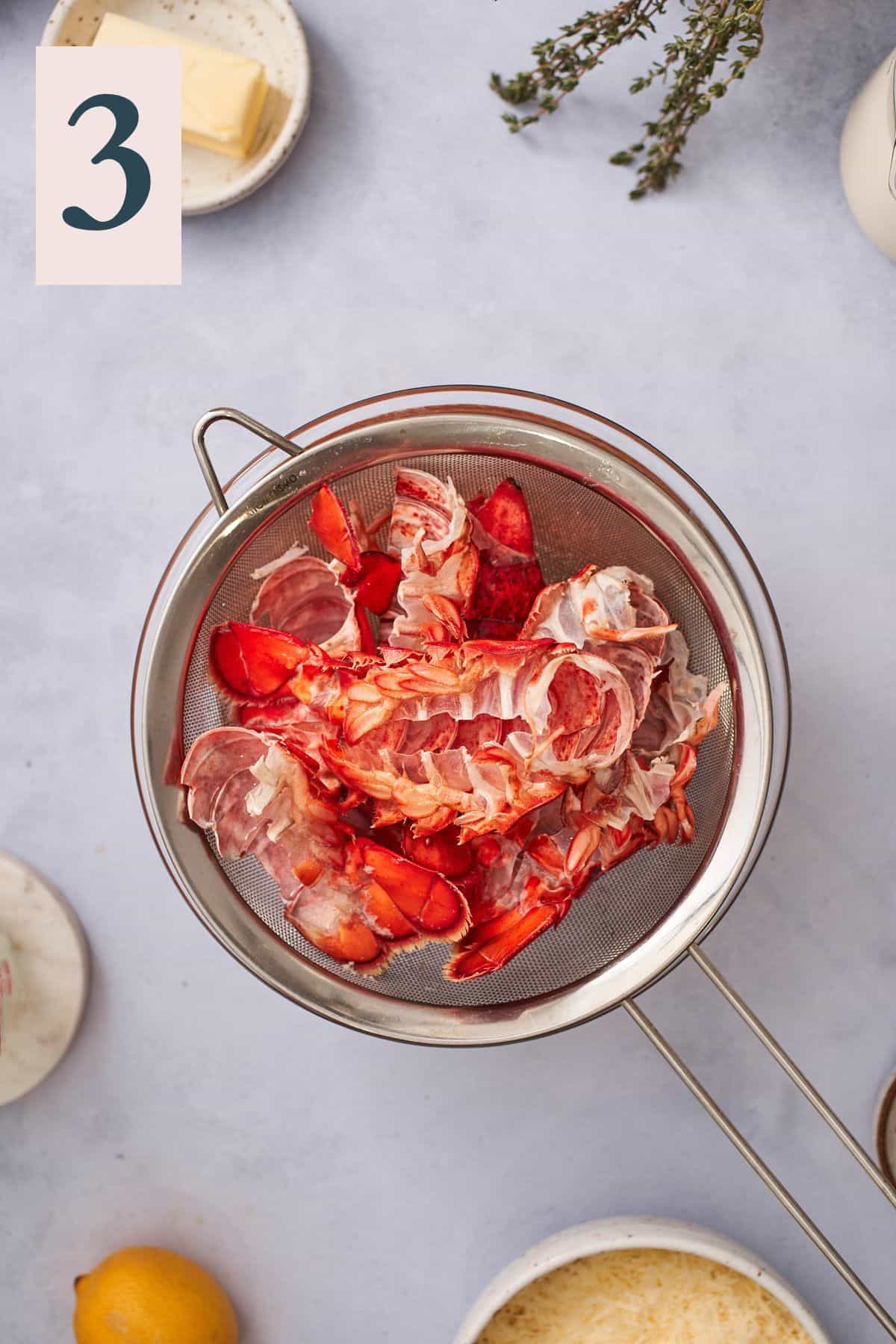cooked bright red lobster shells over a metal sieve. 