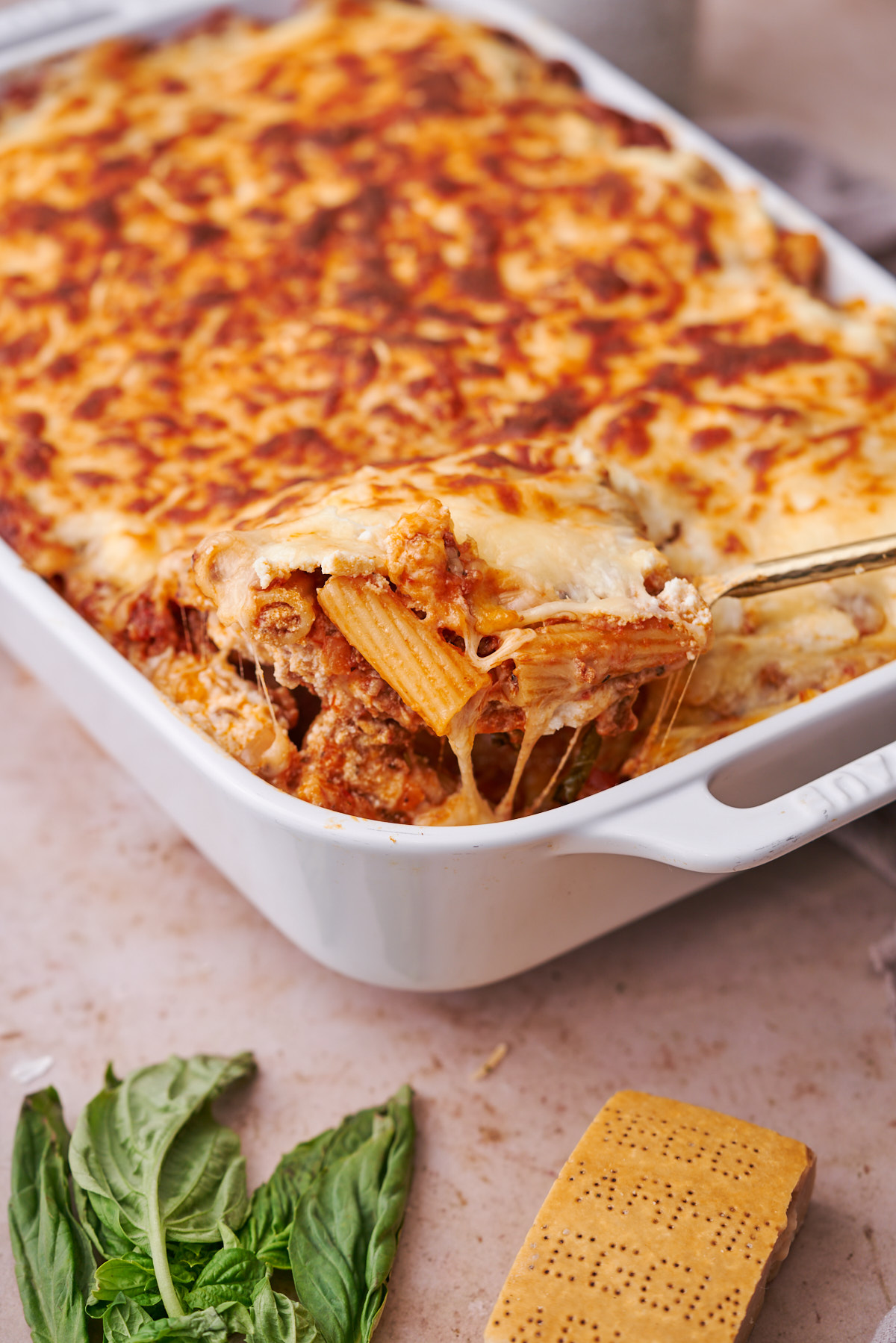 close up shot of baked rigatoni with meat sauce in a large casserole dish. 