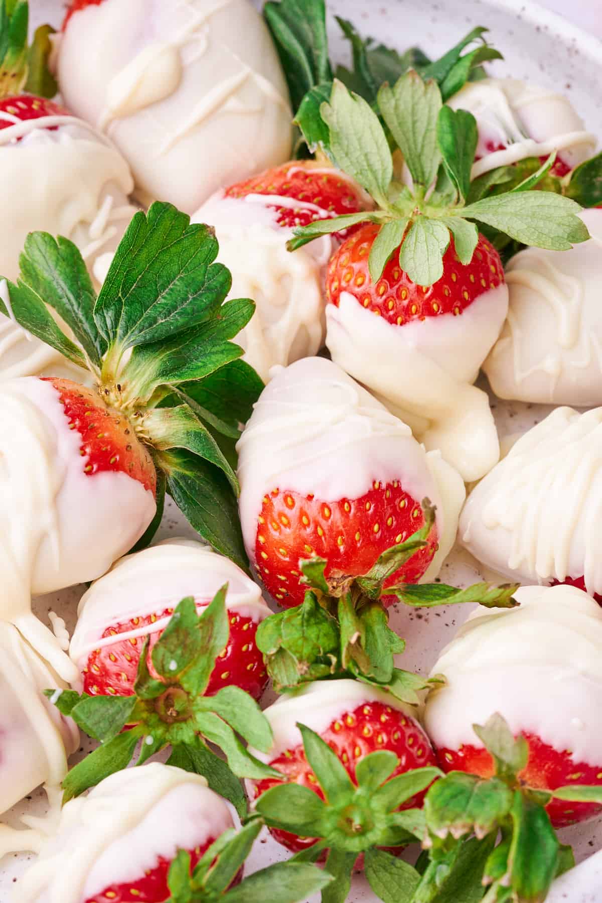 White chocolate covered strawberries on a plate.