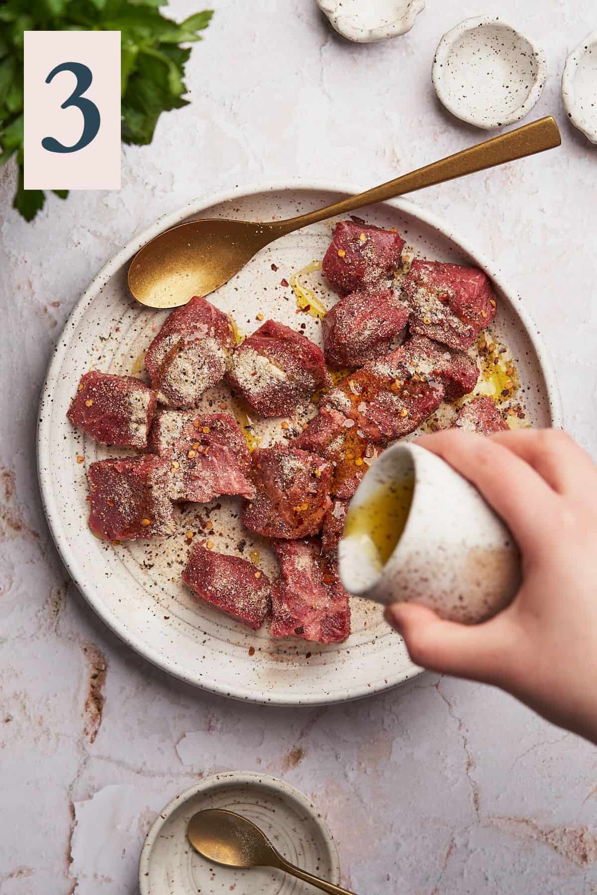 Coating steak in olive oil to fry better.