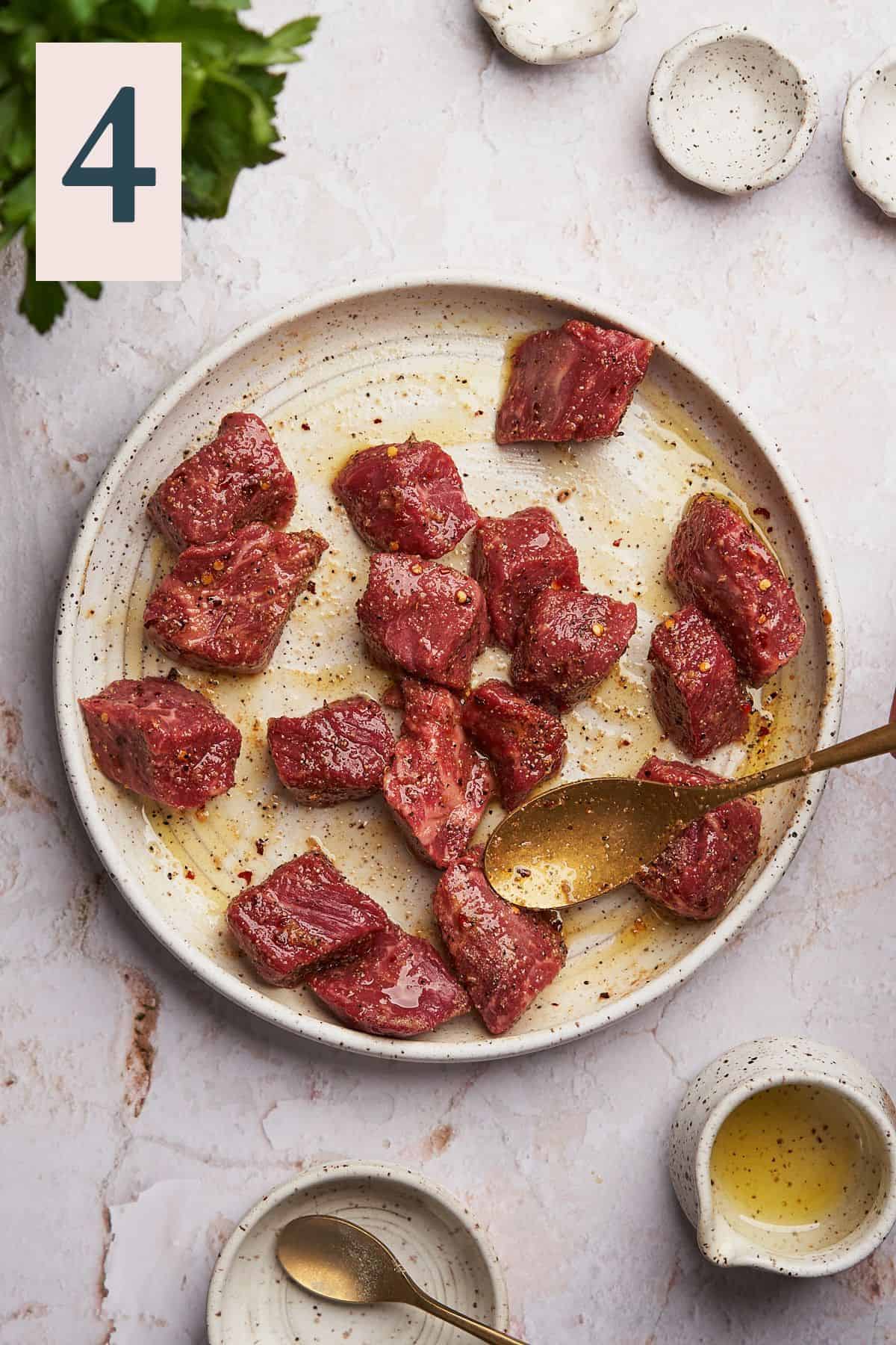 Mixing steak together well with spice blend and olive oil.