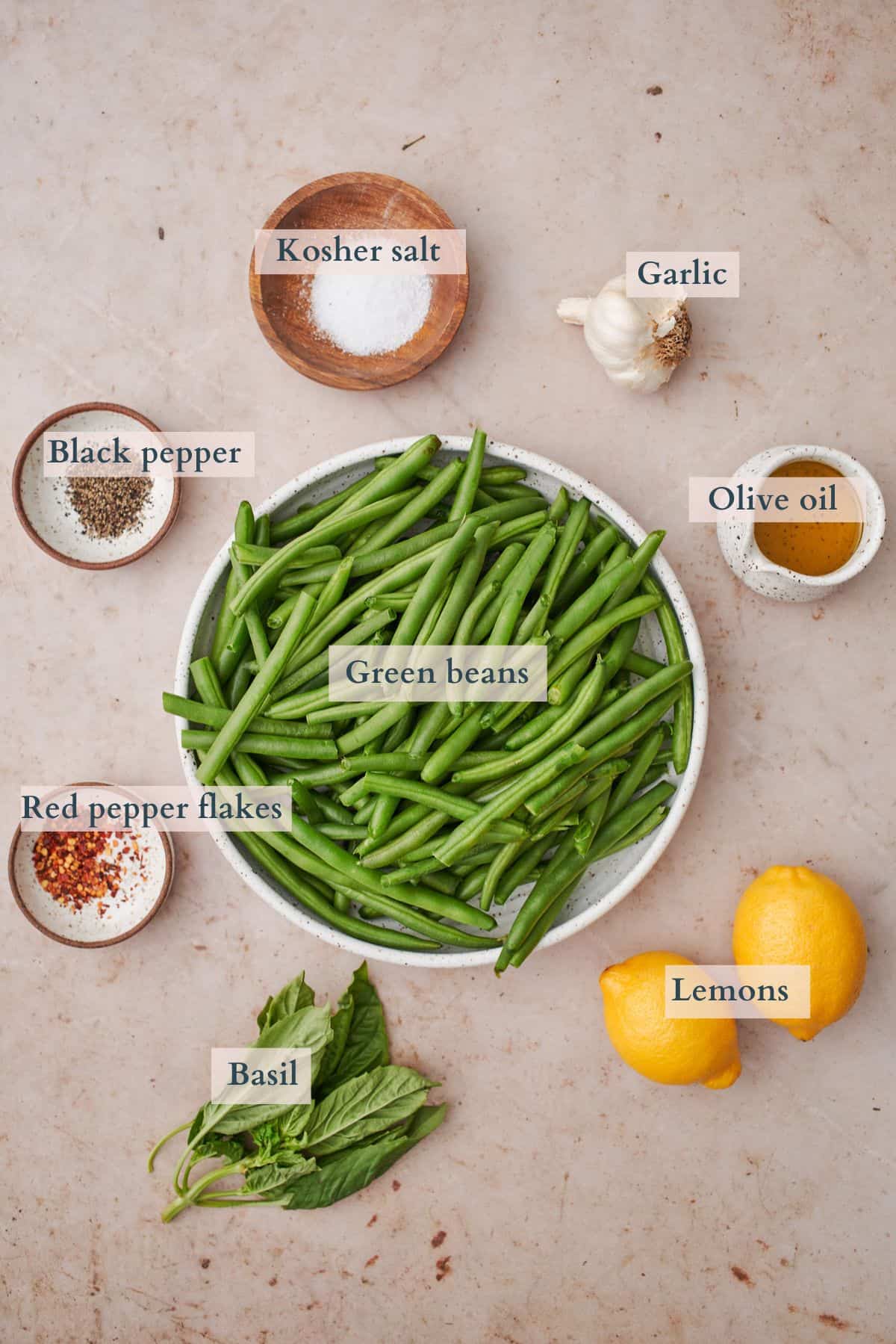 Ingredients for lemon garlic green beans laid out in various bowls and containers.