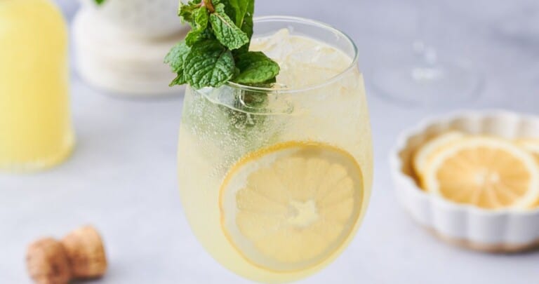 Limoncello Spritz with a sprig of mint, ice, and lemon in the drink.