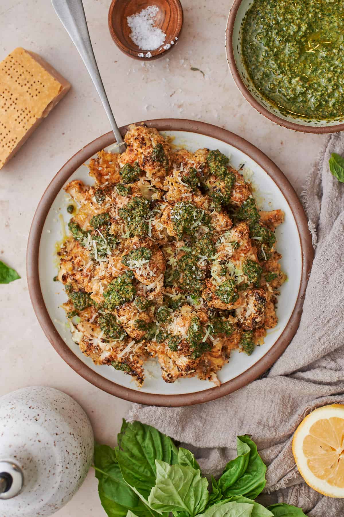 crispy cauliflower topped with pesto sauce and parmesan cheese.