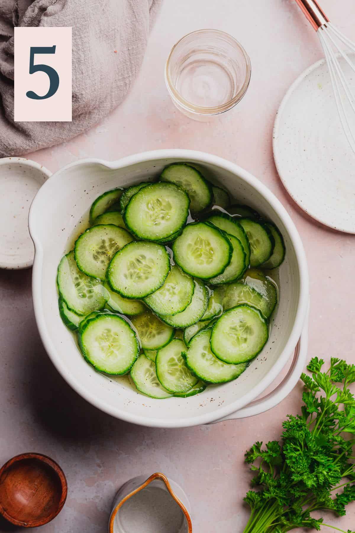 Cucumbers combined with vinegar mixture to sit in the fridge and absorb flavor for 30 minutes.