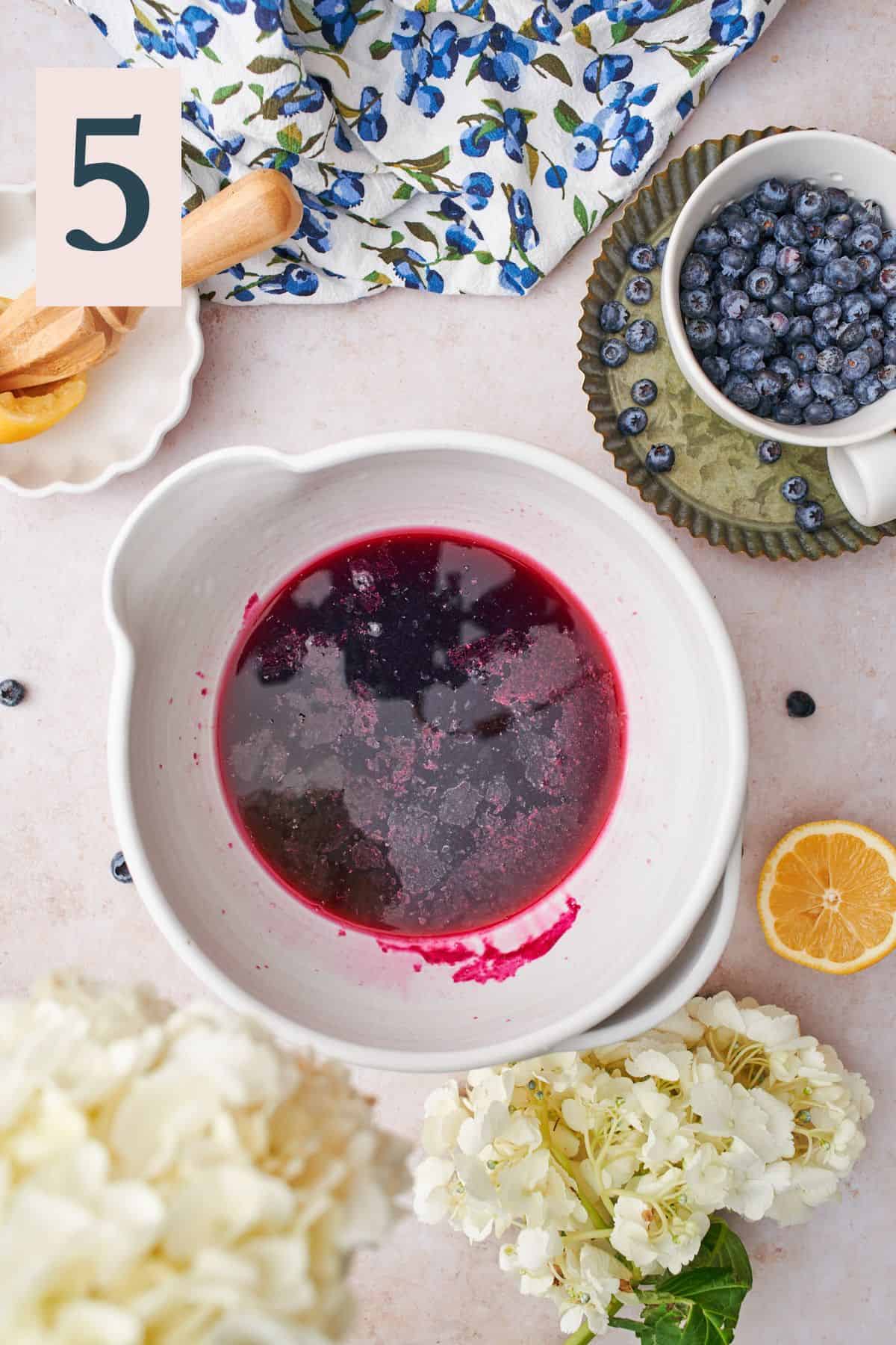 bowl full of blueberry simple syrup with lemon juice added. 