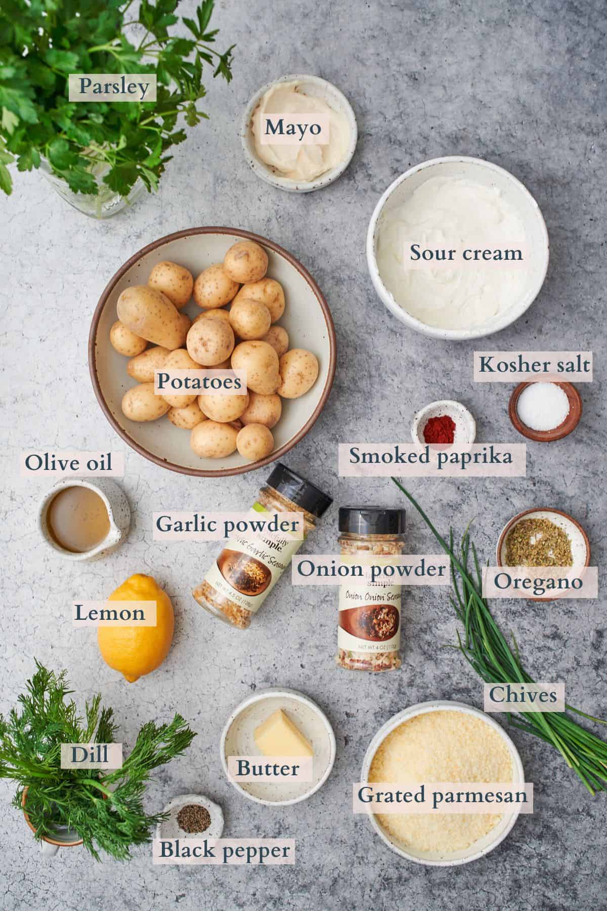 ingredients to make crispy parmesan potatoes laid out in small bowls and labeled to denote each ingredient.