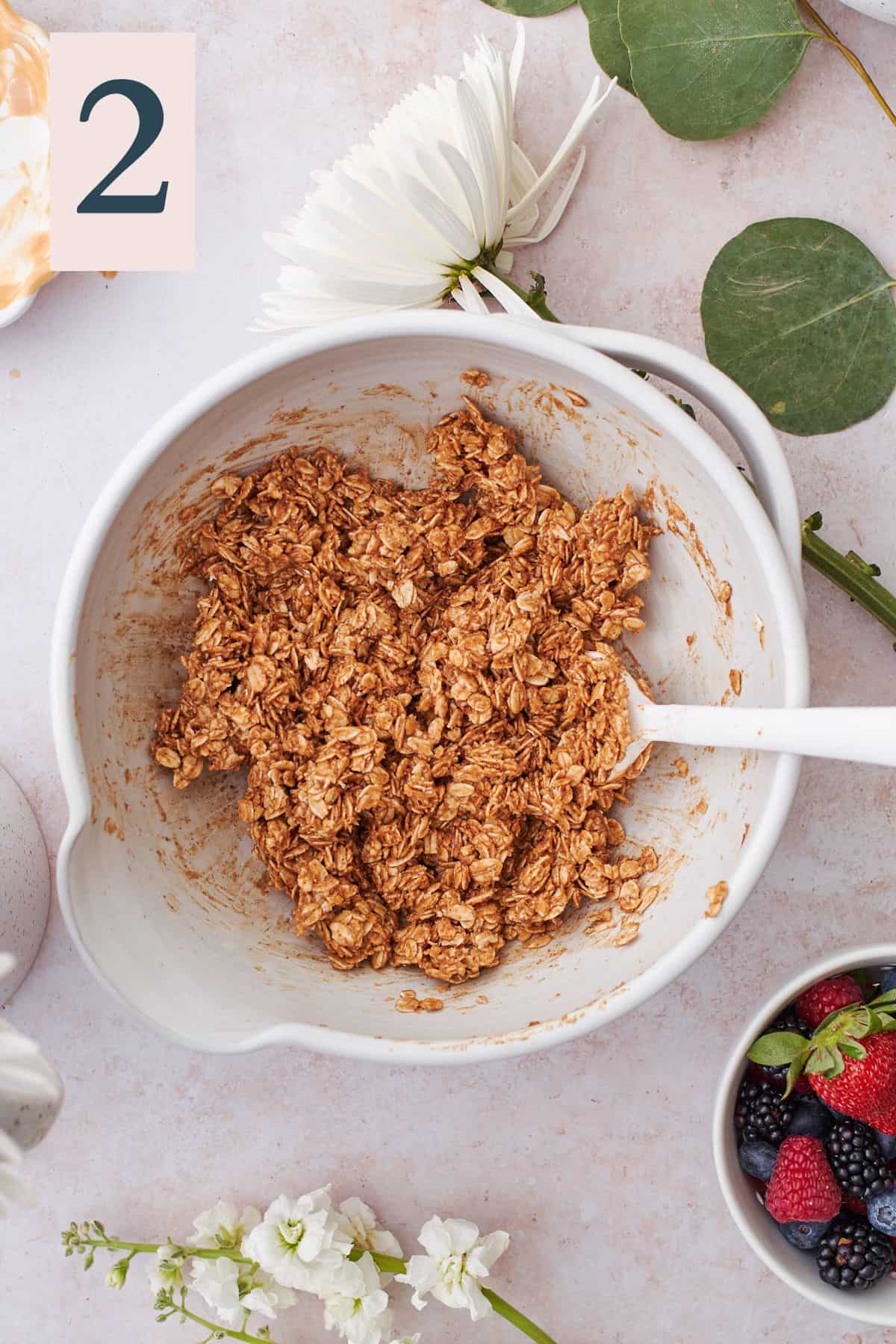 granola base with peanut butter in a ceramic mixing bowl.