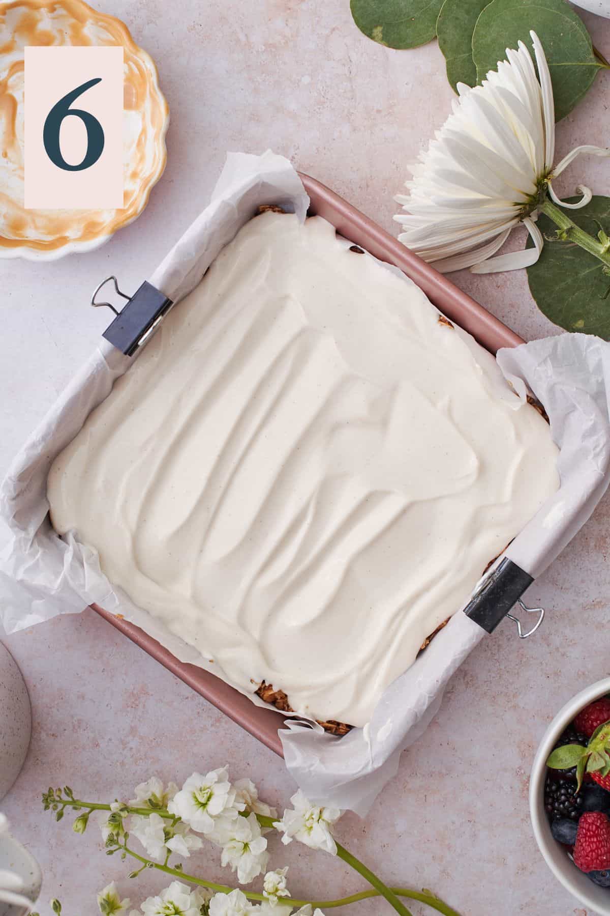 smooth vanilla yogurt spread in a baking pan with a granola base. 
