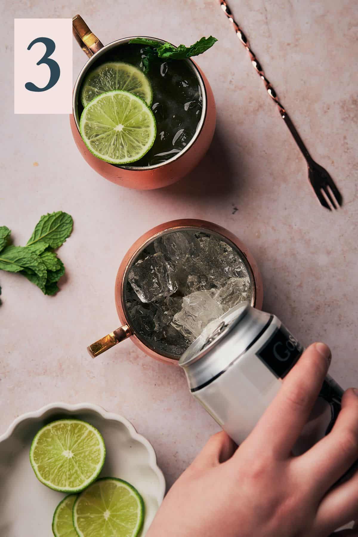 hand pouring in ginger beer into a copper mug to top off a drink.