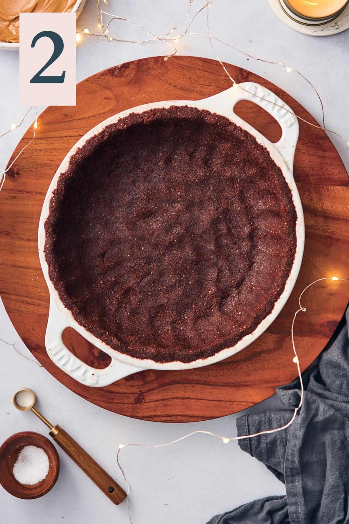 chocolate crust pressed into a white Staub pie plate.