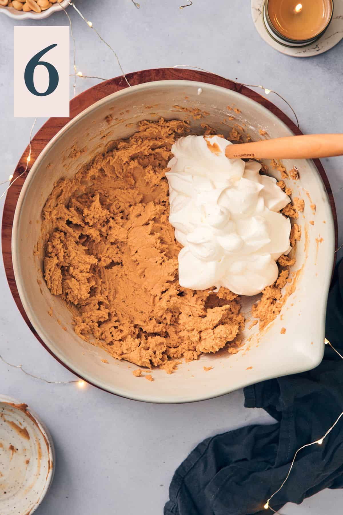 whipped cream in a large mixing bowl with peanut butter and cream cheese. 