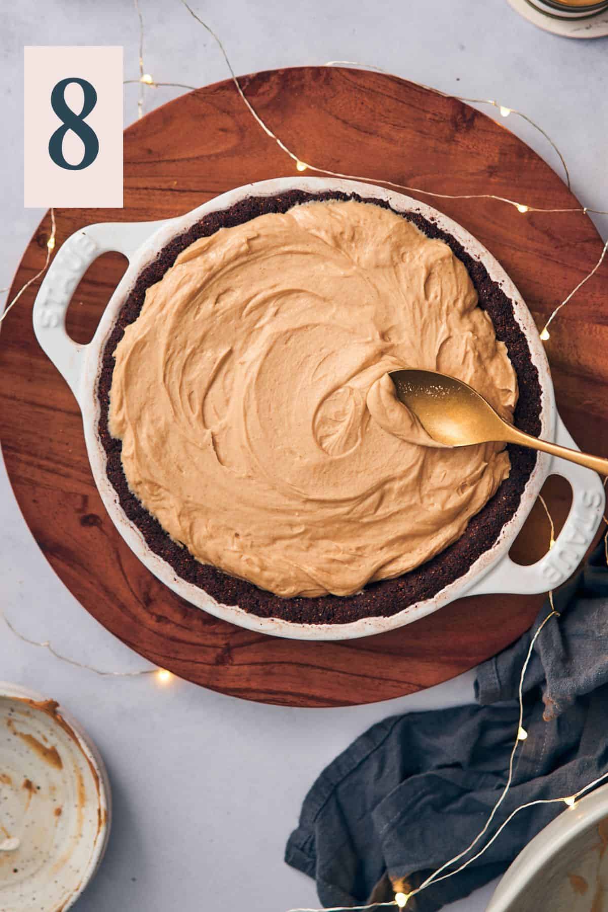 spreading the peanut butter filling into a baked chocolate pie crust. 