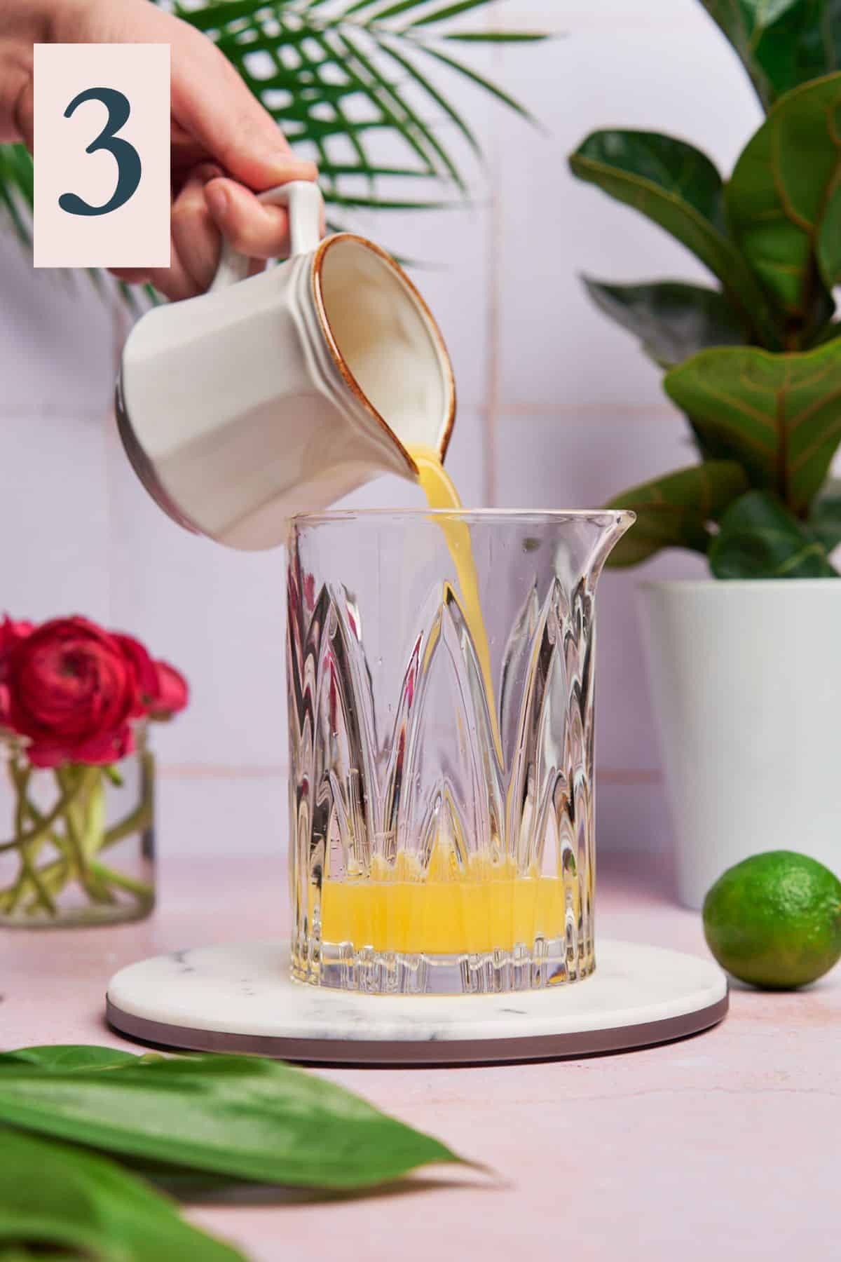 Pineapple juice being poured into cocktail mixer.