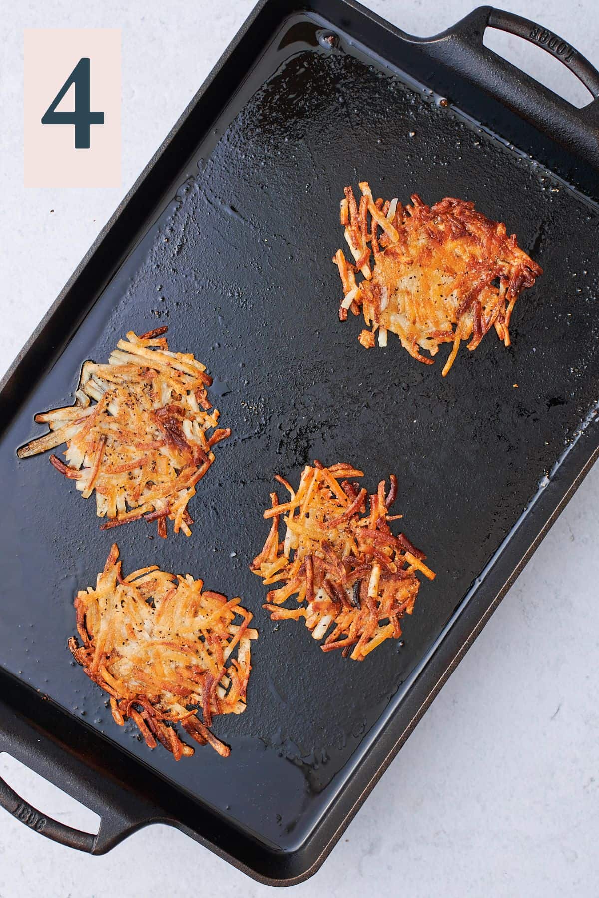 cooked crispy and golden brown hash brown rounds on a griddle. 