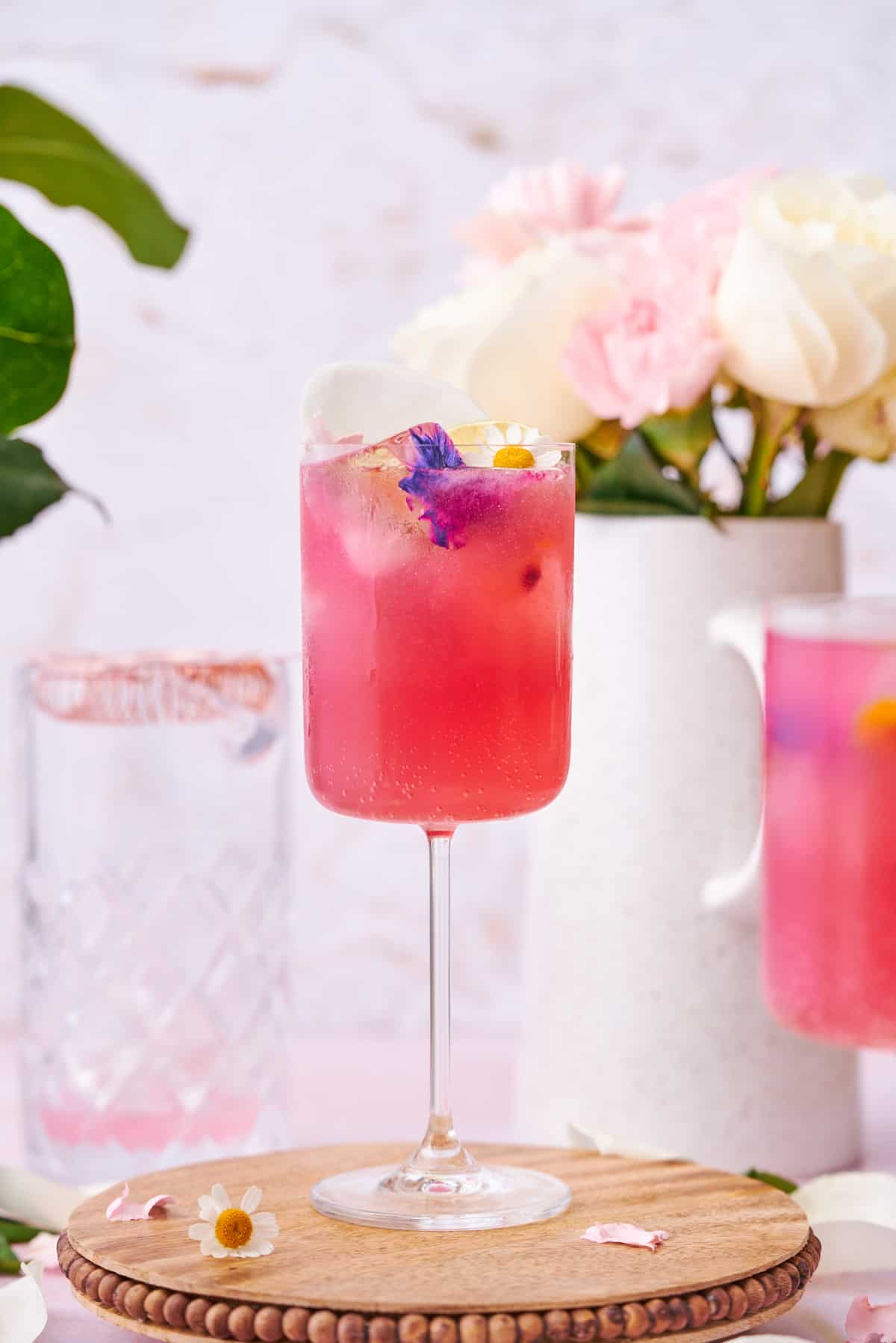 stunning pink floradora cocktail with white roses and pink carnations in the background. 