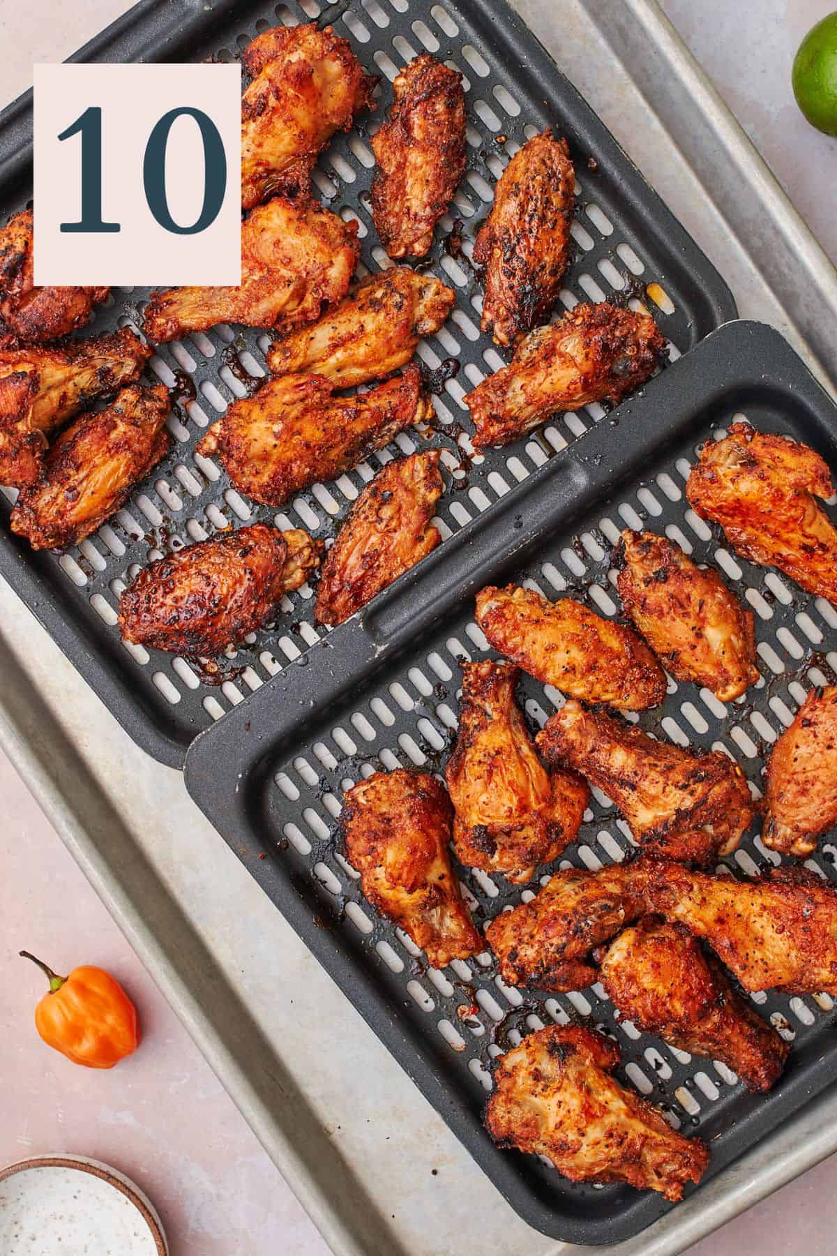 Cooked crispy and spicy chicken wings on air fryer trays. 