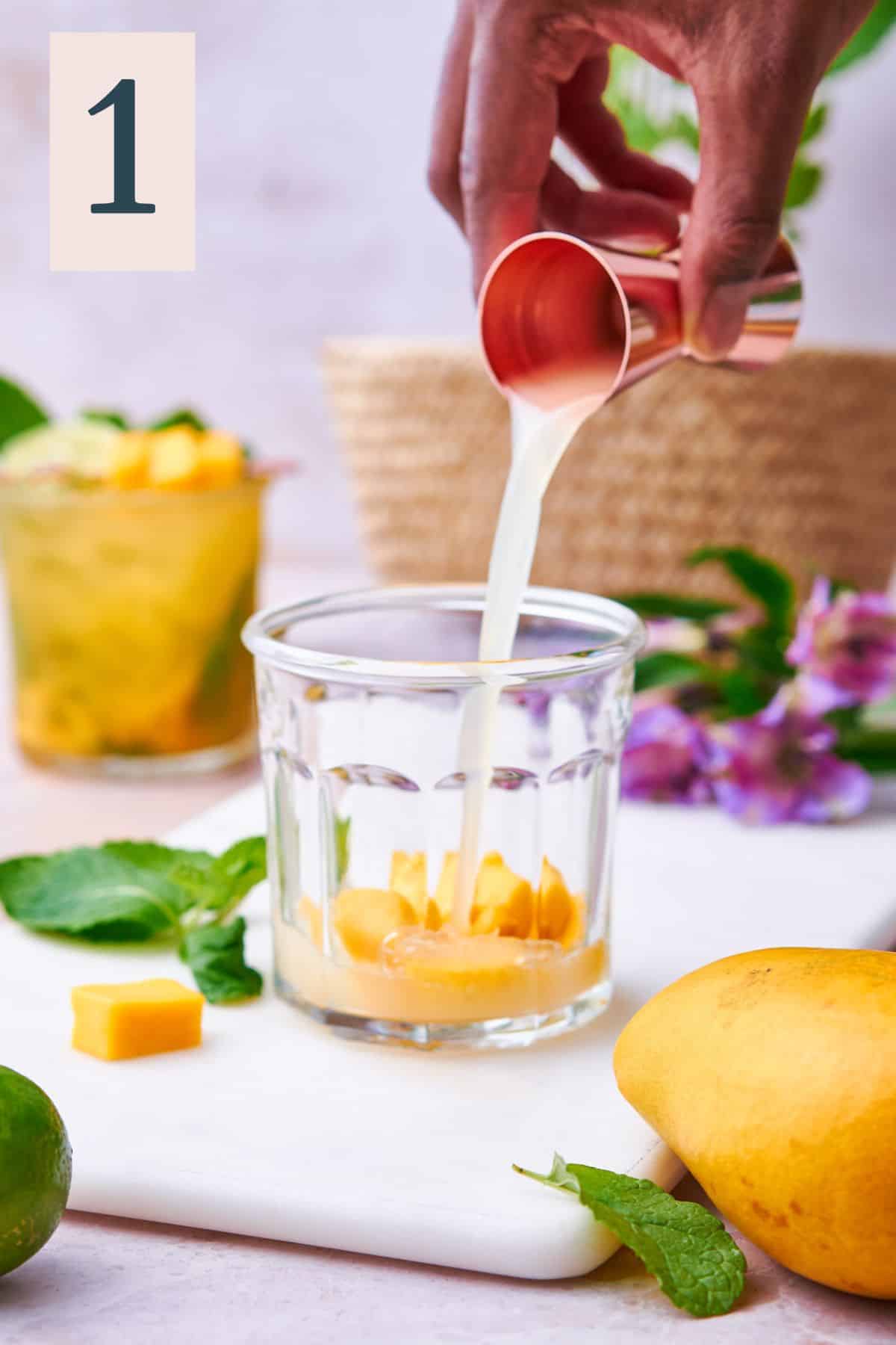Mango chunks and lime juice in a short glass.