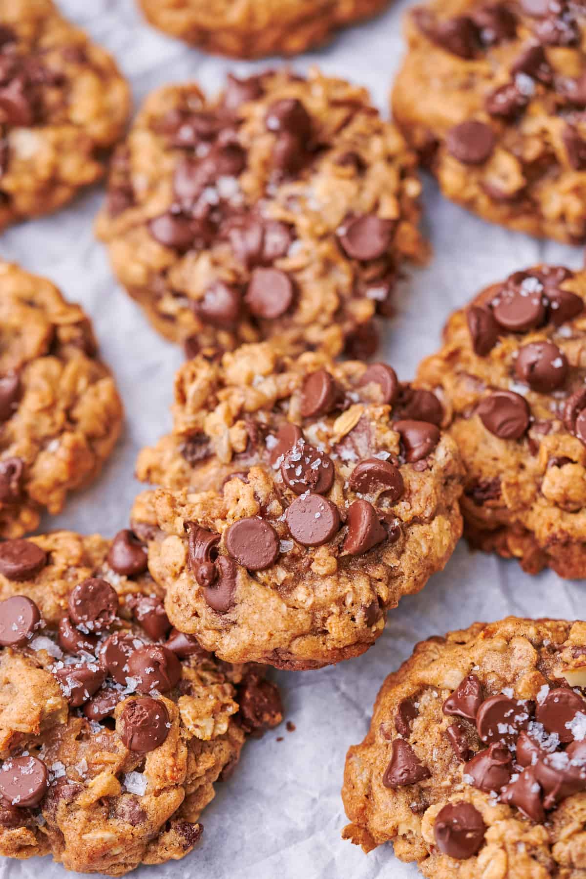 stack of muesli cookies packed with chocolate chips and topped with flaky sea salt. 