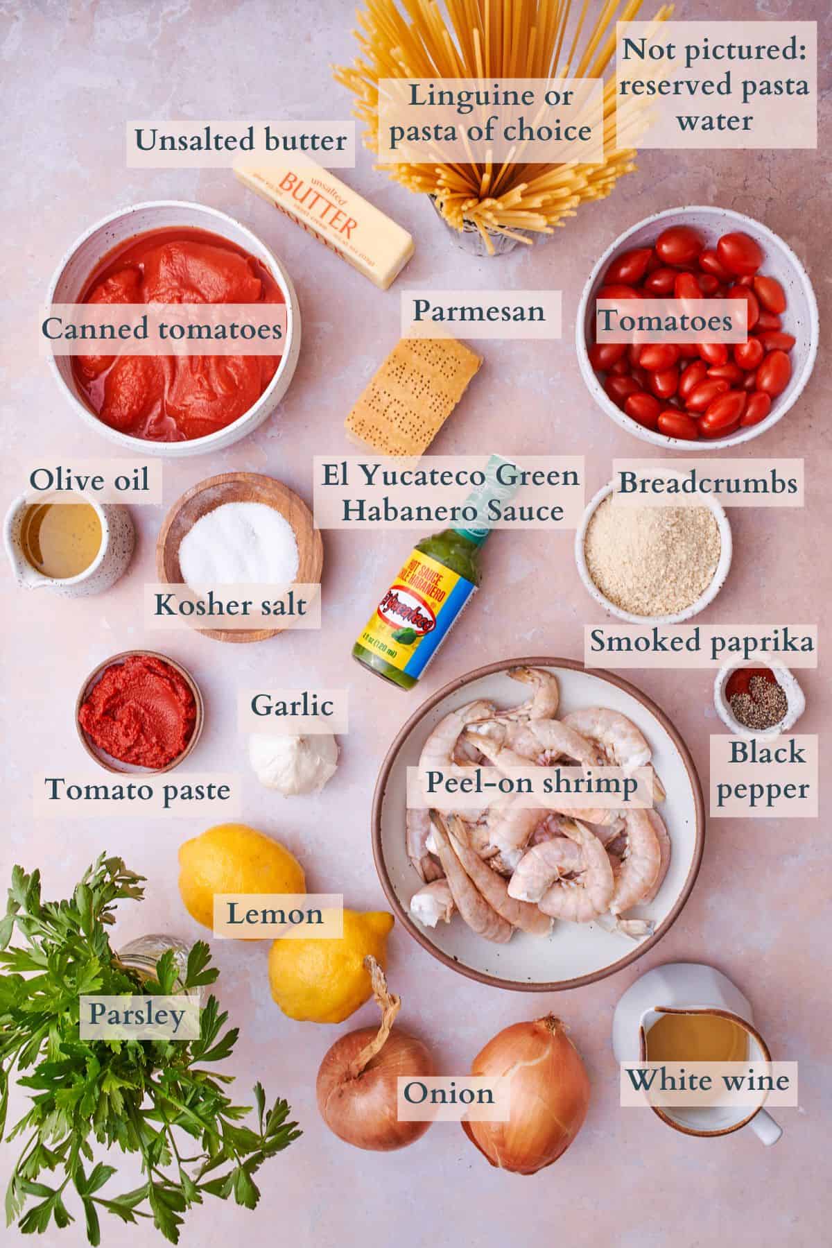 ingredients to make spicy shrimp pasta with text overlaying to denote each ingredient. 