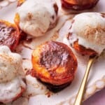 Air fryer peaches topped with ice cream, and a brown sugar cinnamon mixture.