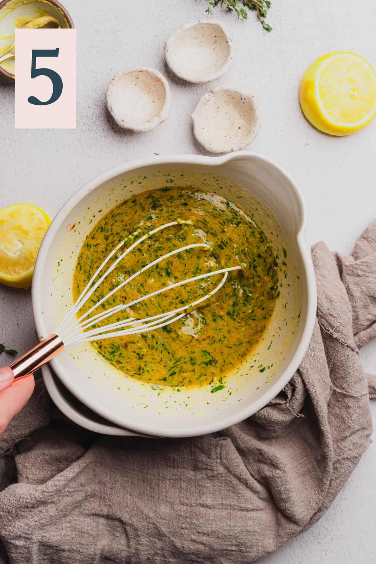whisking together melted butter with herbs, lemon, spices, shallots, and garlic.