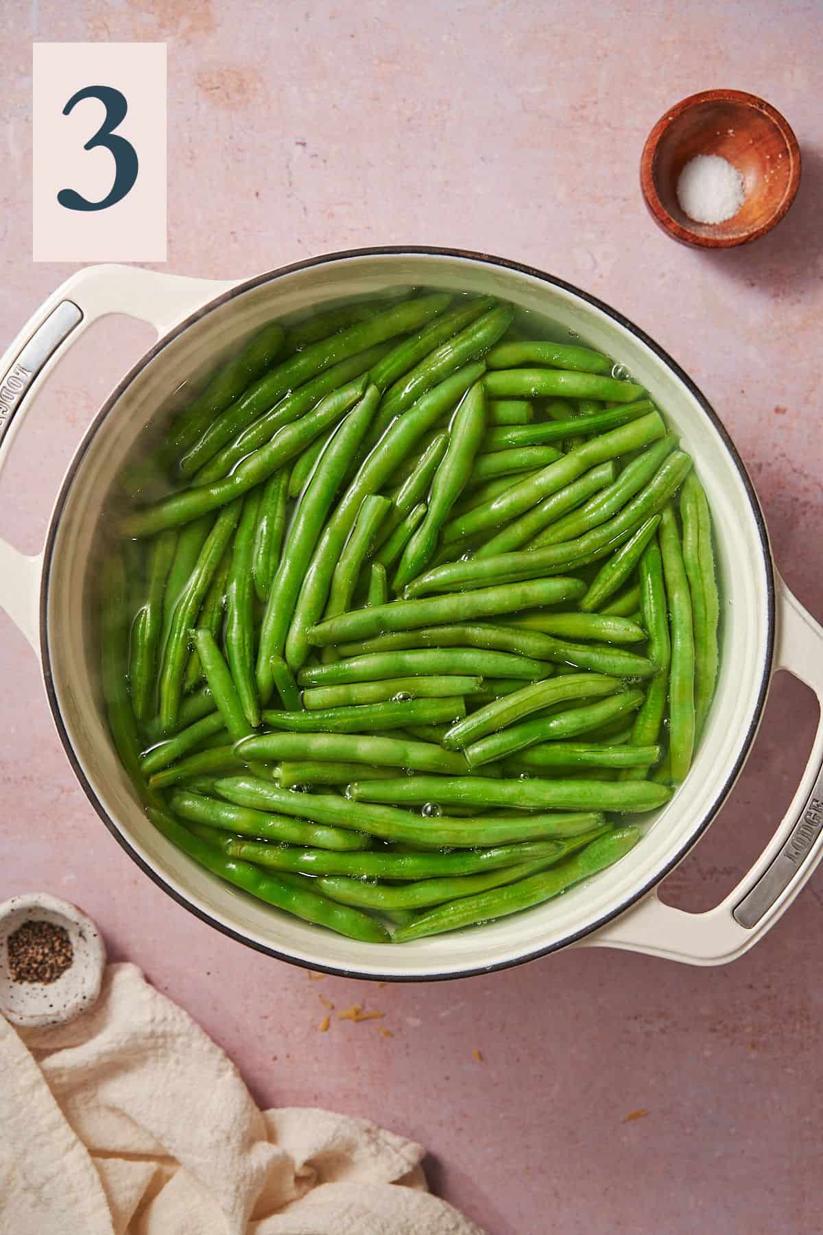 blanching green beans cooking in a pot of hot salted water. 